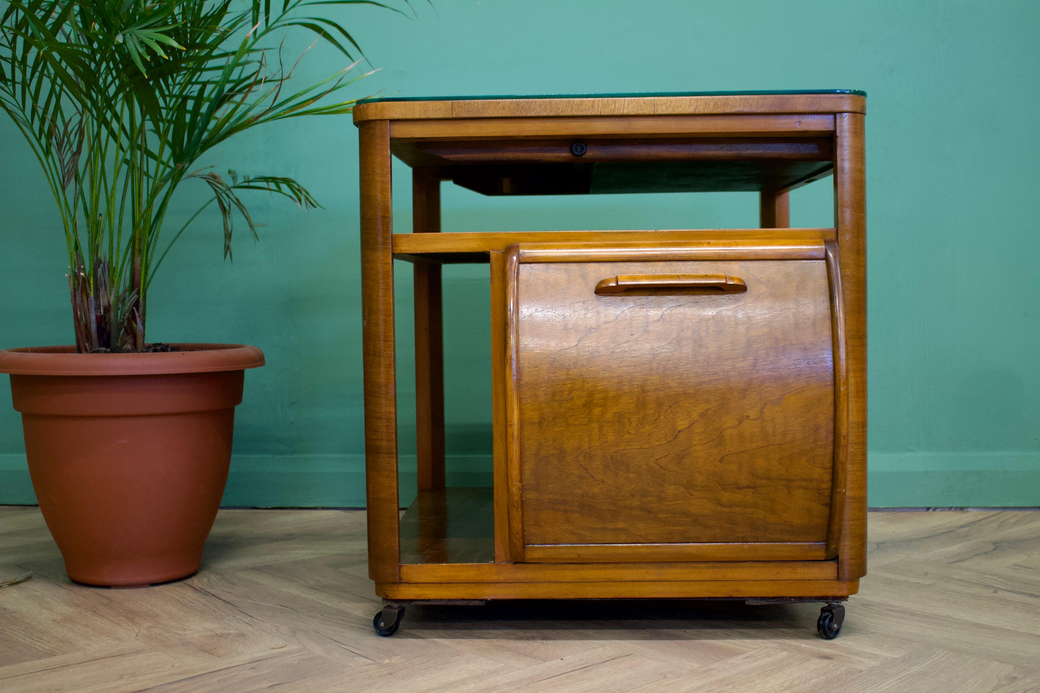 A walnut Art Deco drinks trolley / coffee table by Incorporall

Featuring two pull down doors and a glass top (which can be used without)

There is a pull out drinks tray and additional storage underneath this

The piece sits on castors.