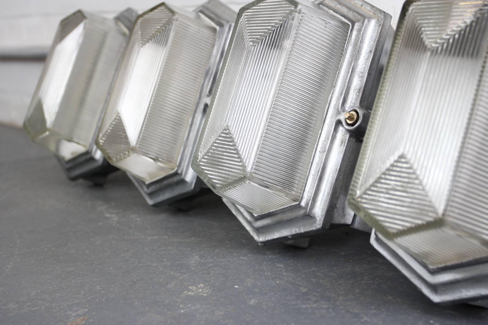 Art Deco industrial bulkhead lights by Maxlume, circa 1930s.

Product code #OA479

- Price is per light (8 available)
- Cast steel casings
- Heavy prismatic glass 
- Takes B22 fitting bulbs
- Wires directly into a wall feed
- English, circa