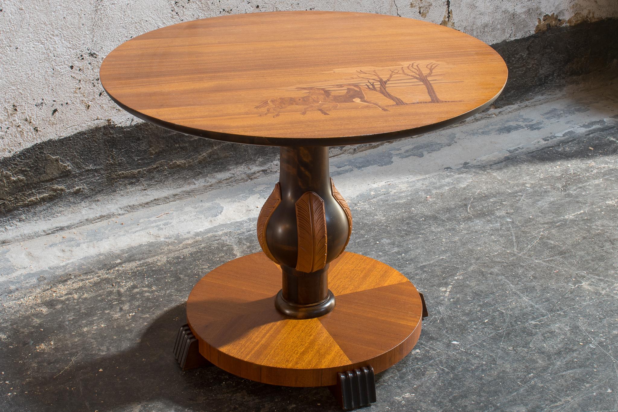 Round end table or side table in the Swedish Art Deco style. Pedestal table was made in Sweden, circa 1930. Mahogany table top features beautiful intarsia inlay depicting two horses and trees in Jacaranda, Elm and Burled Birch. Tabletop sits on
