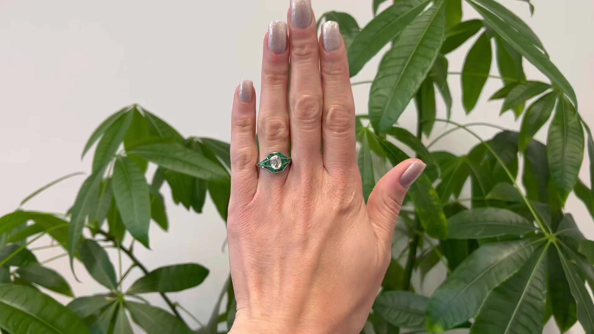 One Art Deco Inspired 1.04 Carat Emerald Cut Diamond and Emerald Platinum Ring. Featuring one emerald cut diamond weighing 1.04 carats, graded F color, VVS2 clarity. Crafted in 26 calibré cut emeralds with a total weight of approximately 0.80 carat.