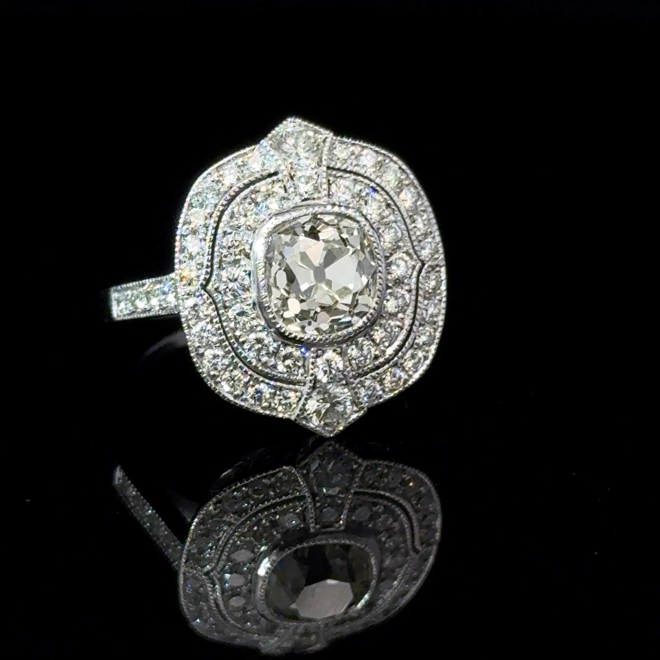 Art Déco inspired white gold 18 Karat ring. 

The ring is set with a center old mine diamond of 1.52 Carats ( estimated H/ I color - Vs clarity) and surrounded with 0.77 Carats brilliant diamonds ( estimated H/I color - Vs clarity). 

All the