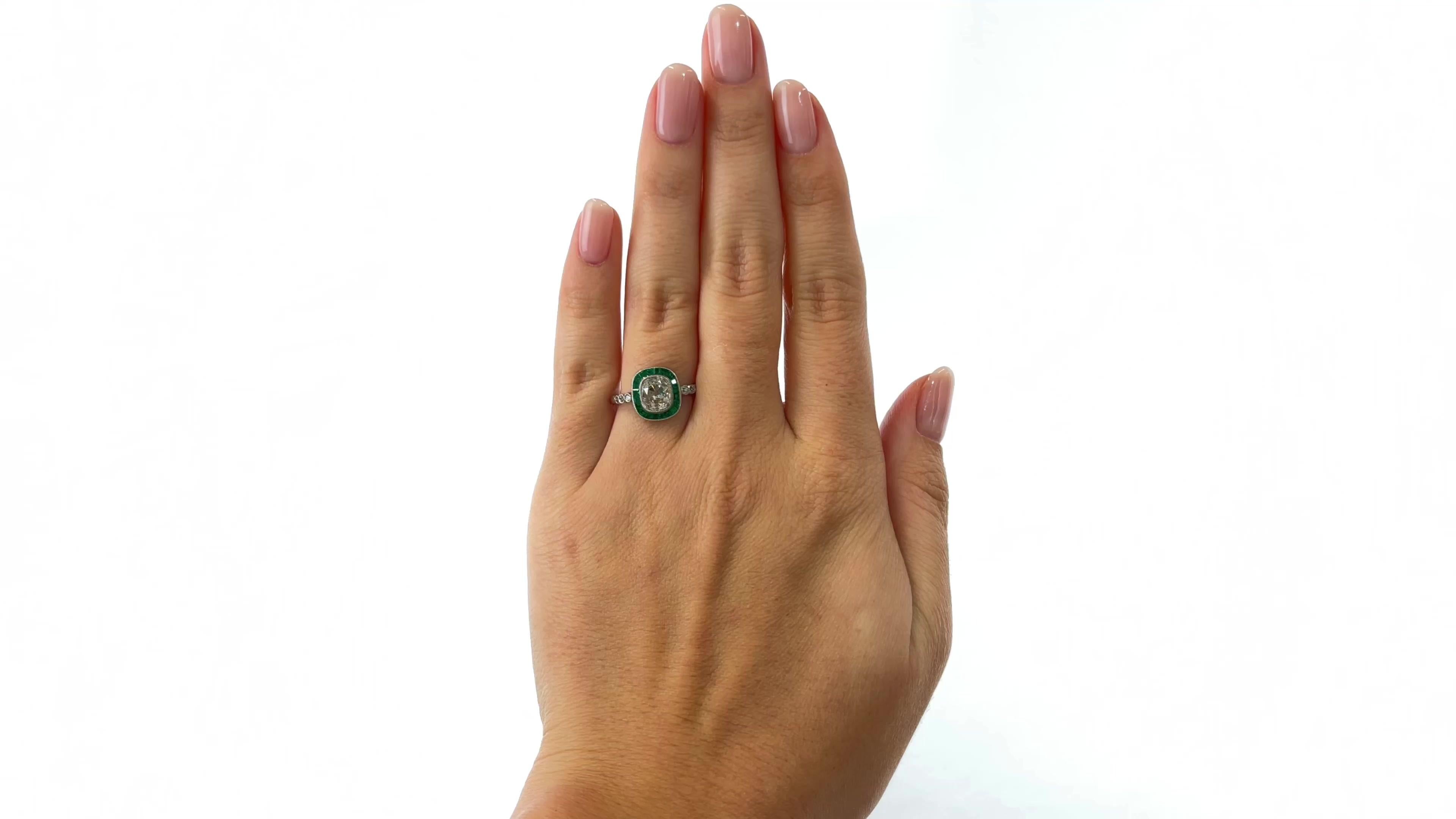 One Art Deco Inspired 1.62 Carat Old Mine Cut Diamond Emerald Platinum Engagement Ring. Featuring one 1.62 carat old mine cut diamond, graded L color, VS2 clarity. Accented by 20 calibré cut emeralds with a total weight of approximately 0.40 carats,