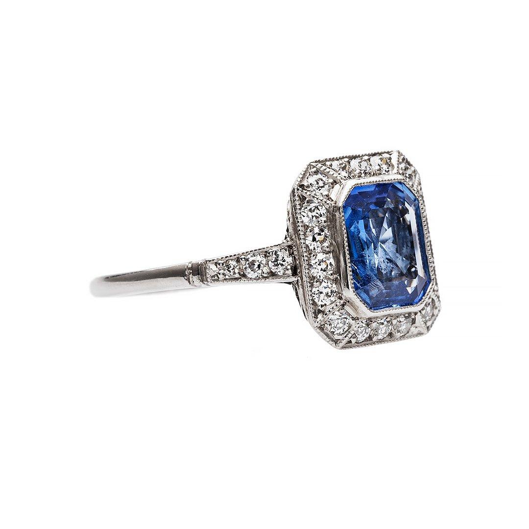 Illustrious design that provides stability and strength through geometric design. Designed with a 1.65 carat royal blue sapphire that is certified as Ceylon origin with no indications of heat treatment. Highlighted by a radiating halo of near