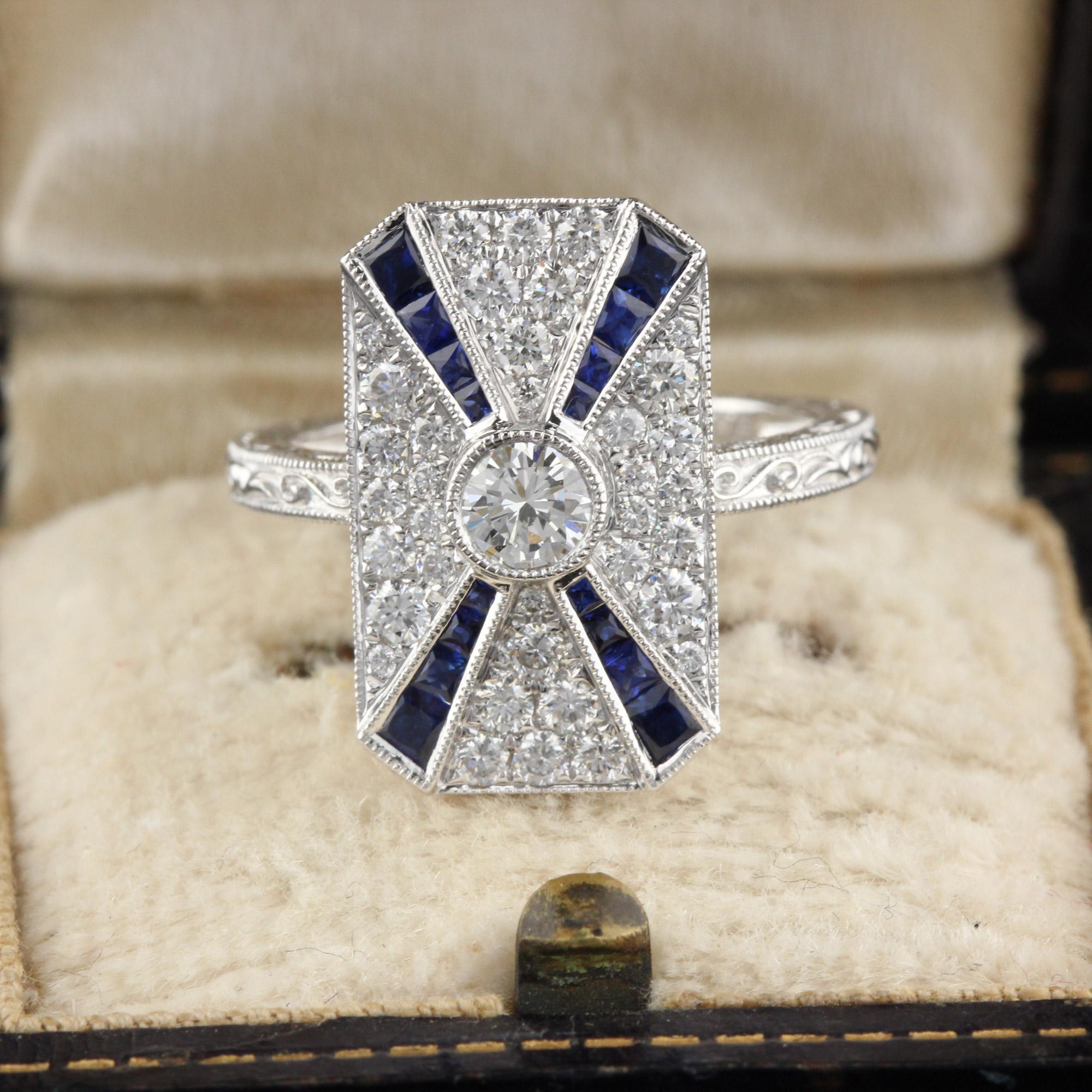 Beautiful Art Deco style ring in 18K White Gold with diamonds and channel set natural sapphires! This ring is hand engraved and mil-grained. 

#R0066

Metal: 18K White Gold

Center Diamond Weight: 0.25 cts 

Total Diamond Weight: 0.89cts

Diamond