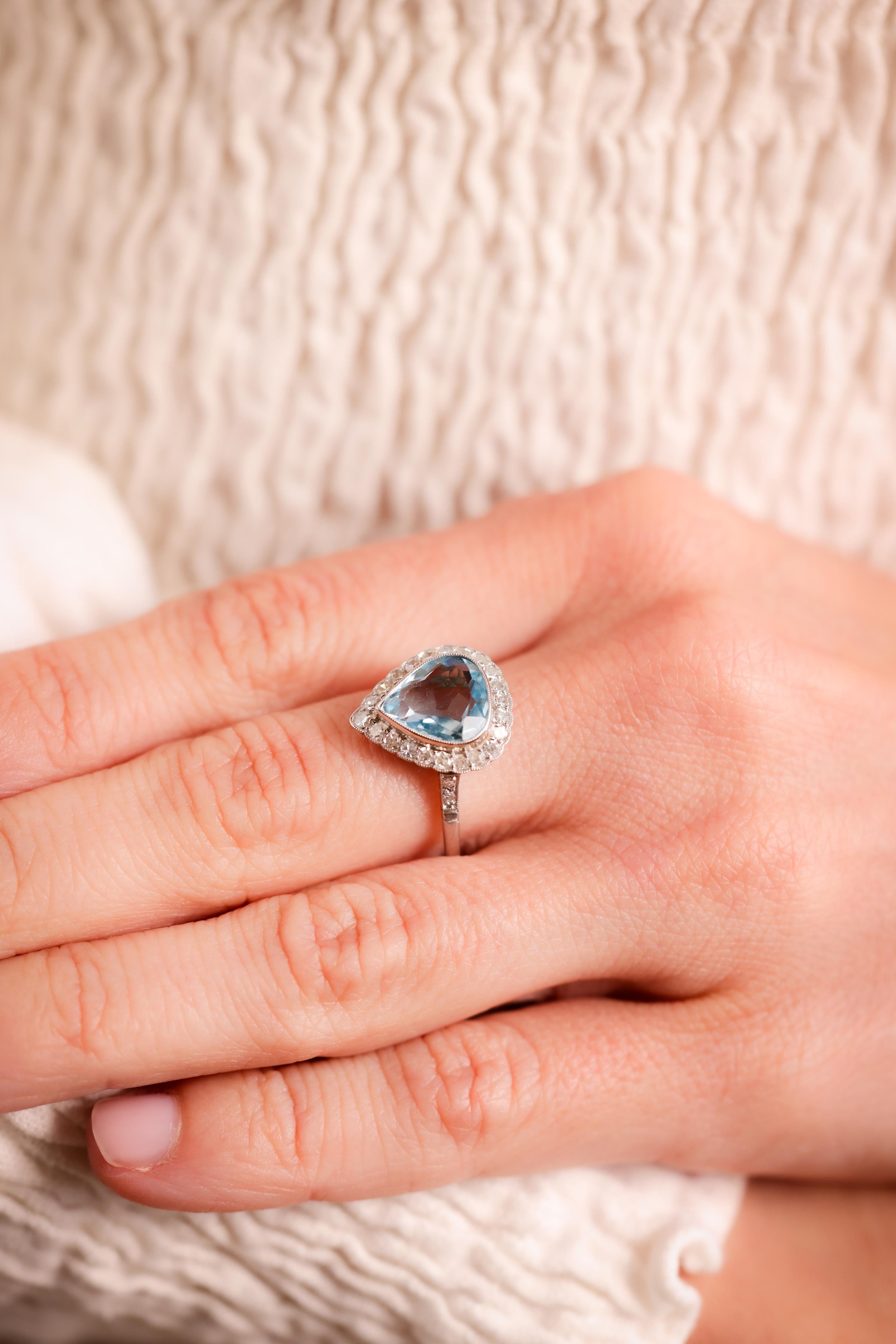 Center Stone: Aquamarine
Cut: Pear
Weight: 2.14 Carat
Color: Blue
Accent Stone: 26 Diamonds
Cut: Single
Weight: Approximately 0.6 Carats
Color: I
Clarity: SI
Metal: Platinum
Era: Modern in the Style of Art Deco
Circa: 2020's
Hallmarks: Stone Weight