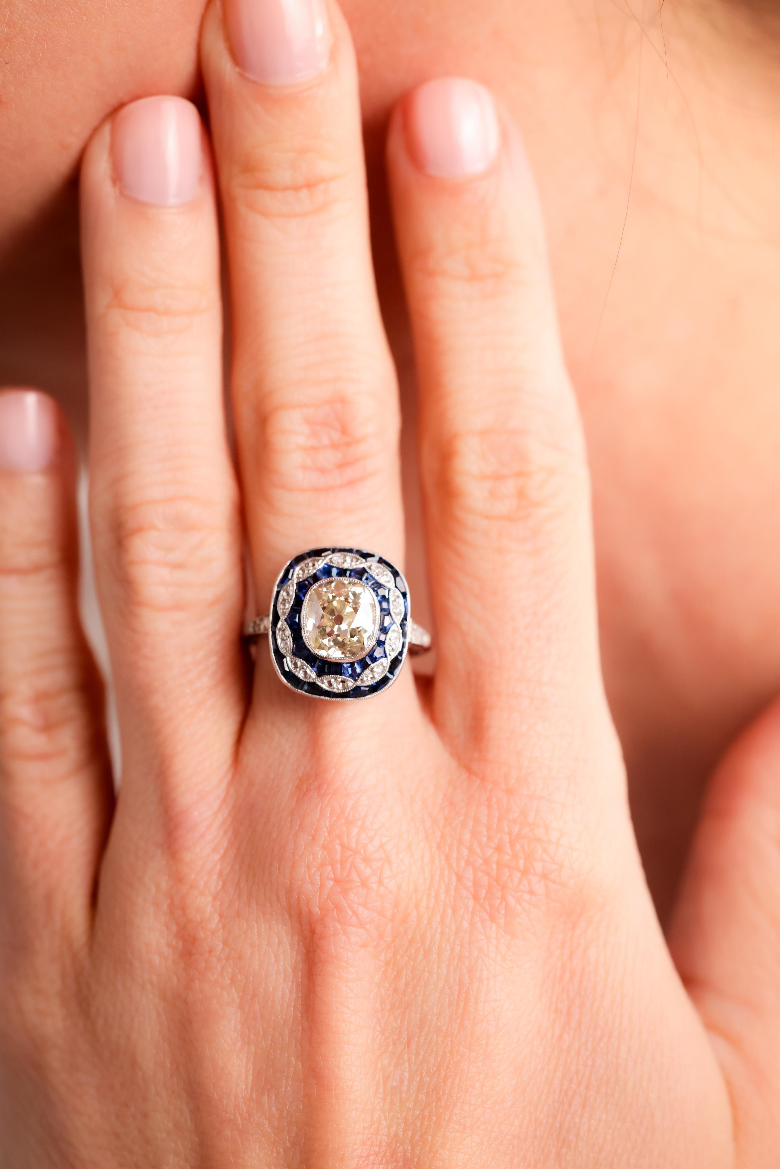 Center Stone: Diamond
Cut: Old Mine Cut
Weight: 2.24 Carat
Color: S-T
Clarity: VS
Accent Stone: 40 Sapphires
Cut: Calibre Cut
Weight: Approximately 2 Carats
Color: Blue
Accent Stone: 26 Diamonds
Cut: Rose Cuts
Weight: Approximately 
Color: