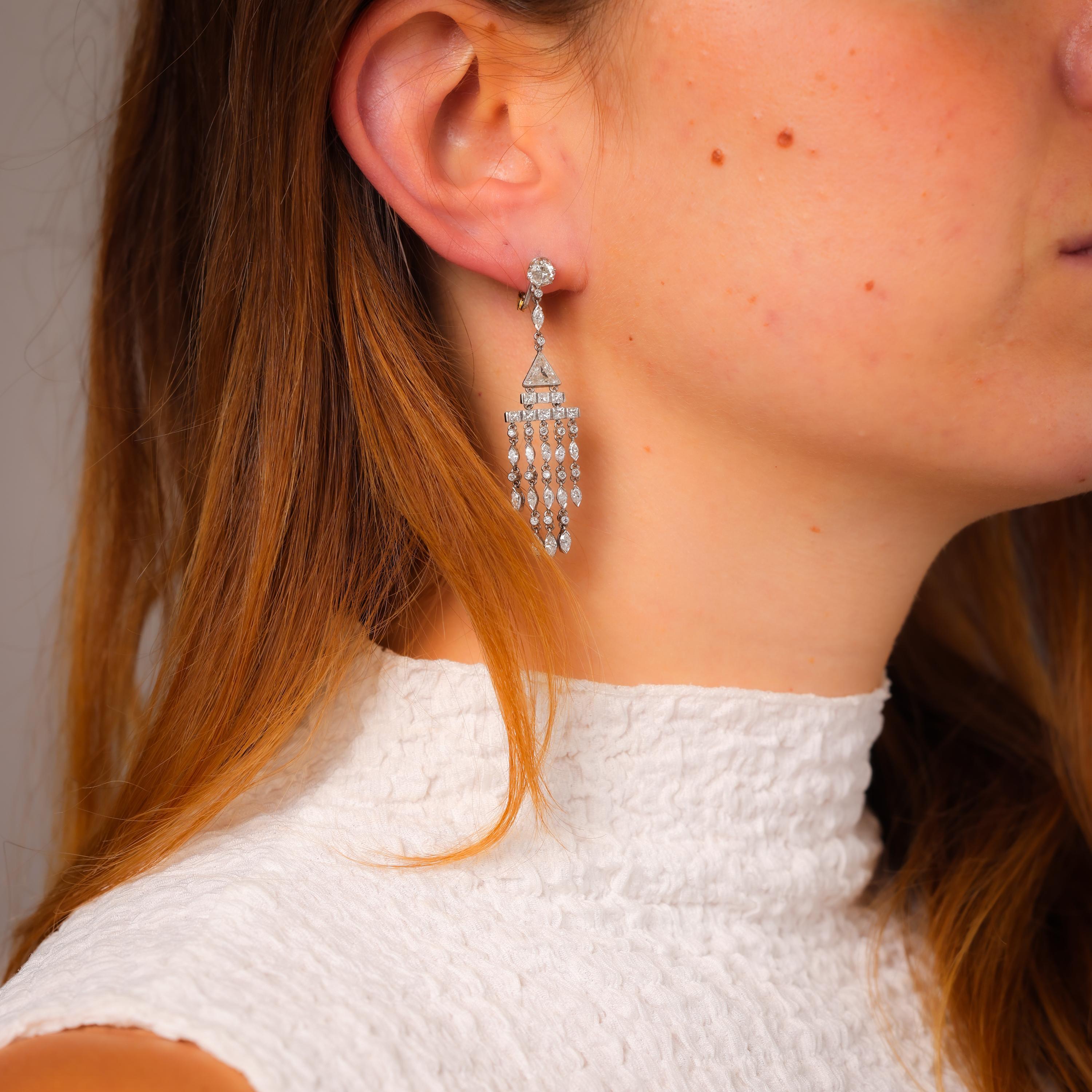 These Art Deco-inspired platinum chandelier earrings dazzle with 6 carats of exquisitely cut diamonds, enhanced by yellow gold backs. A striking tribute to vintage elegance.

Center stone: 78 old European, round brilliant, marquise, princess,