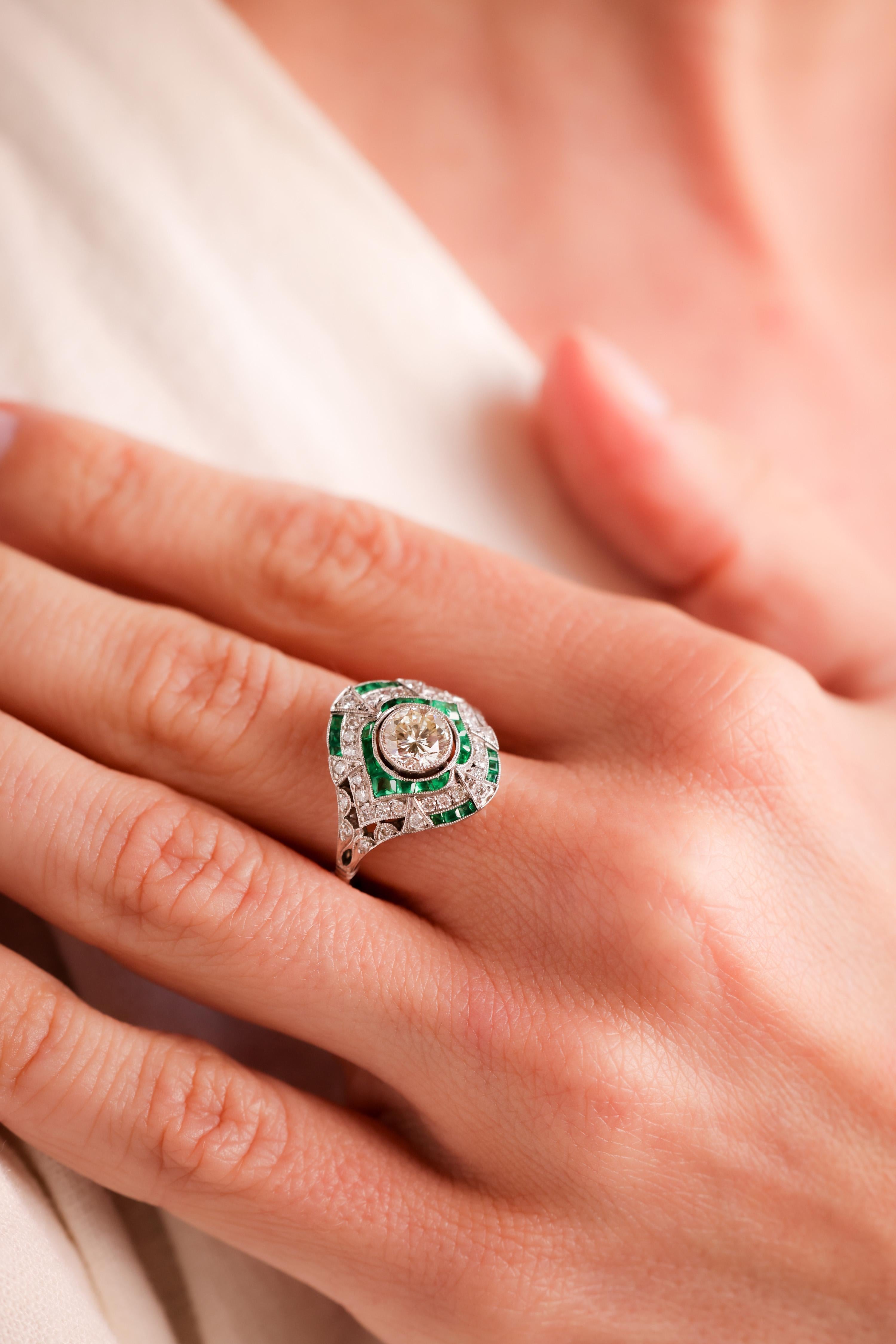 Center Stone: Diamond
Cut: Round Brilliant Cut
Weight: 0.83 Carat
Color: K
Clarity: VS
Accent Stone: 36 Diamonds
Cut: Round Brilliant Cut
Weight: 0.39 Carat
Color: H
Clarity: VS
Accent Stone: 26 Emeralds
Cut: Square and Calibre Cuts
Weight: