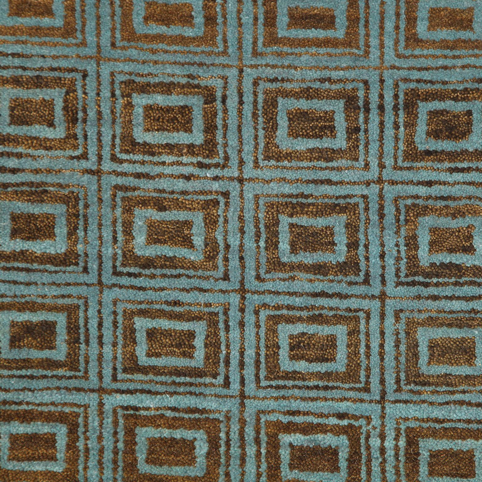 Dieser blaue und braune Perserteppich im Art-Déco-Stil verleiht dem zeitlosen Design eine moderne Note, indem er komplizierte geometrische Muster mit einem unverwechselbaren blau-grünen Farbton verbindet. Das Zusammenspiel von Quadraten, Chevrons
