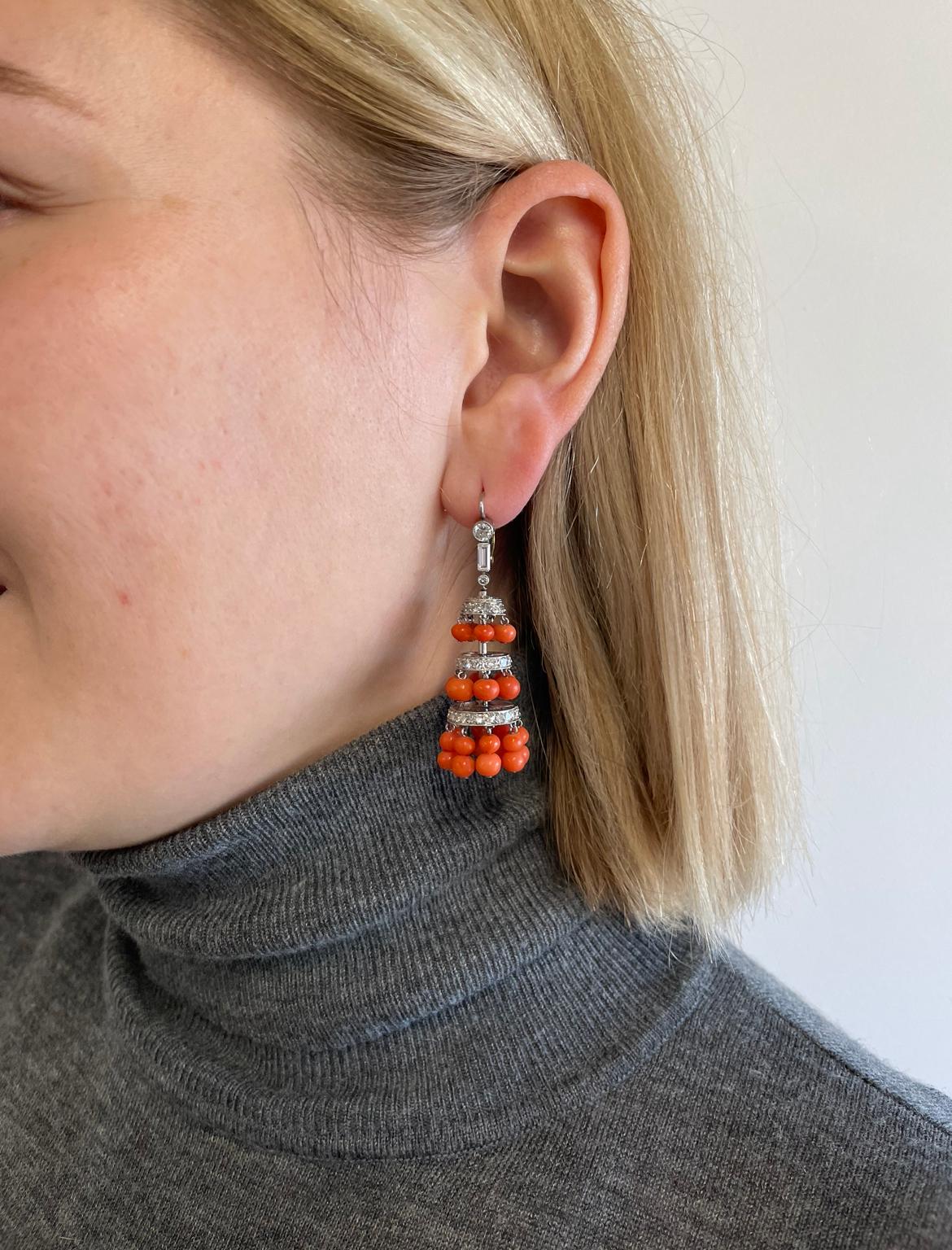 Fun and colorful, these earring will definitely add some spice to your look! Featuring polished coral spheres and 110 single cut and 2 baguette diamonds with a total carat weight of approximately 1.70ct, graded F-G color, VS-SI clarity. Circa