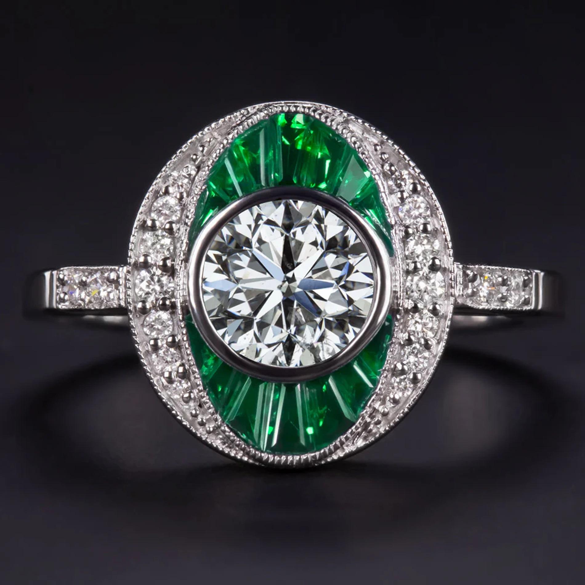 Entdecken Sie zeitlose Eleganz mit diesem atemberaubenden, vom Art Deco inspirierten Diamant- und Smaragdring, der durch seine satte Farbe und sein außergewöhnliches Funkeln besticht! Der Ring ist mit einem hochwertigen Diamanten im Rundschliff