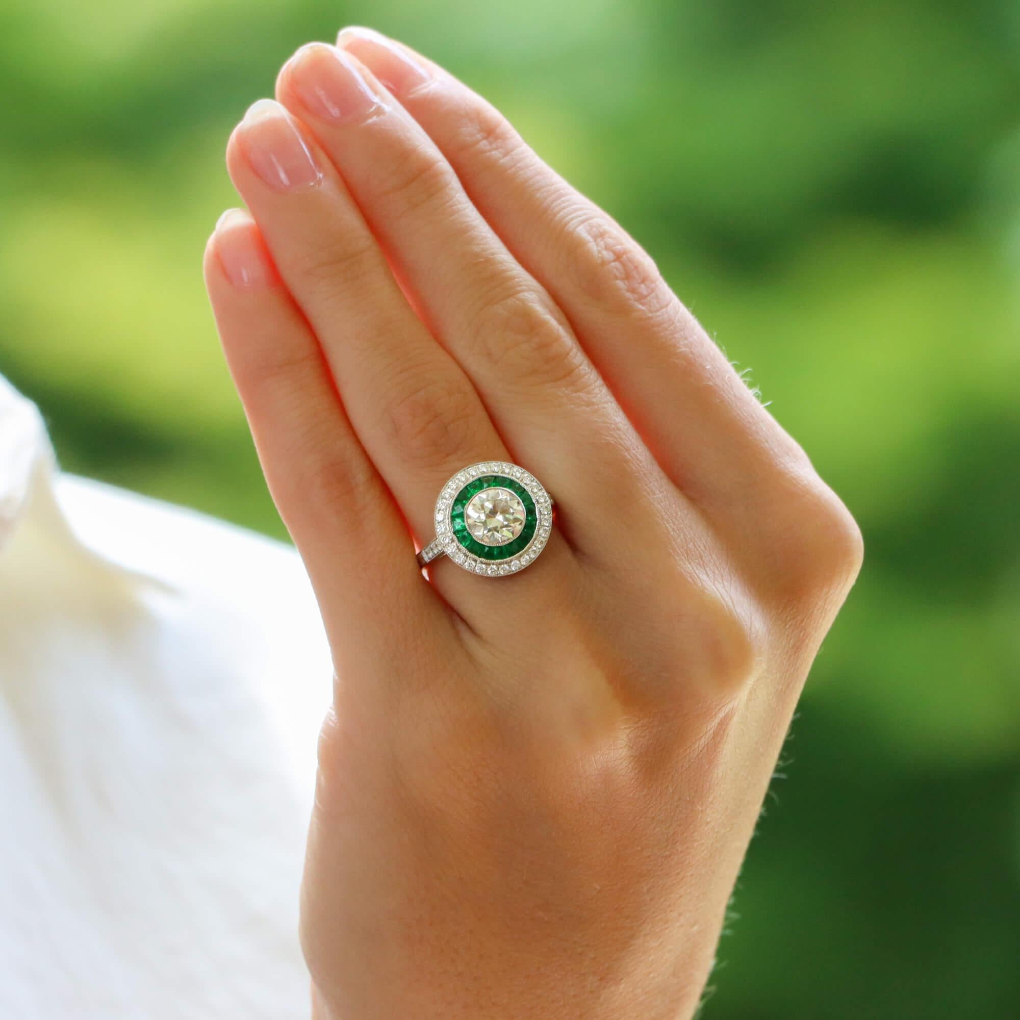 A beautiful Art Deco style emerald and old European cut diamond double target ring set in platinum.

The ring is predominantly set with a sparkly old European cut diamond which is bezel set to centre. Surrounding this beautiful diamond are two