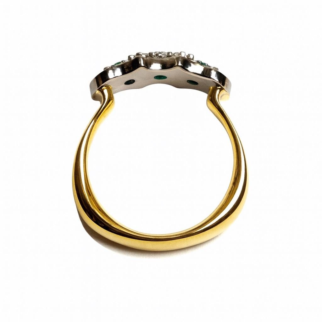 This geometrically playful band ring, reminiscent of the famous Art Deco era, showcases three vibrant green emeralds of the finest color quality. They are framed by four princess-cut diamonds and adorned on both flanks with eight brilliant-cut