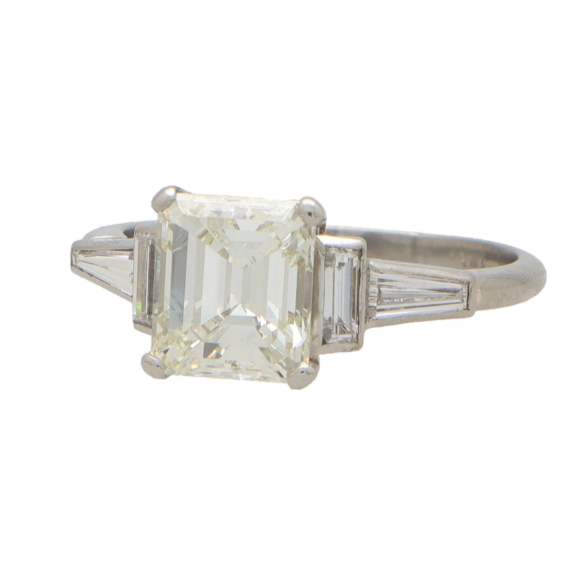 A beautiful Art Deco inspired GIA certified emerald cut diamond ring set in platinum.

The ring is centrally set with a sparkly GIA certified 2.20 carat emerald cut diamond which is securely claw set to centre. The shoulders of the ring are composed