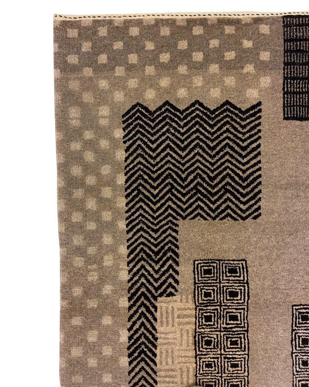 This Art Deco-inspired gray, black, and cream Labyrinth wool Persian rug, sized 3' x 5', is a striking design from Orley Shabahang’s collection. The rug showcases bold geometric patterns that evoke a labyrinthine journey, blending intricate textures