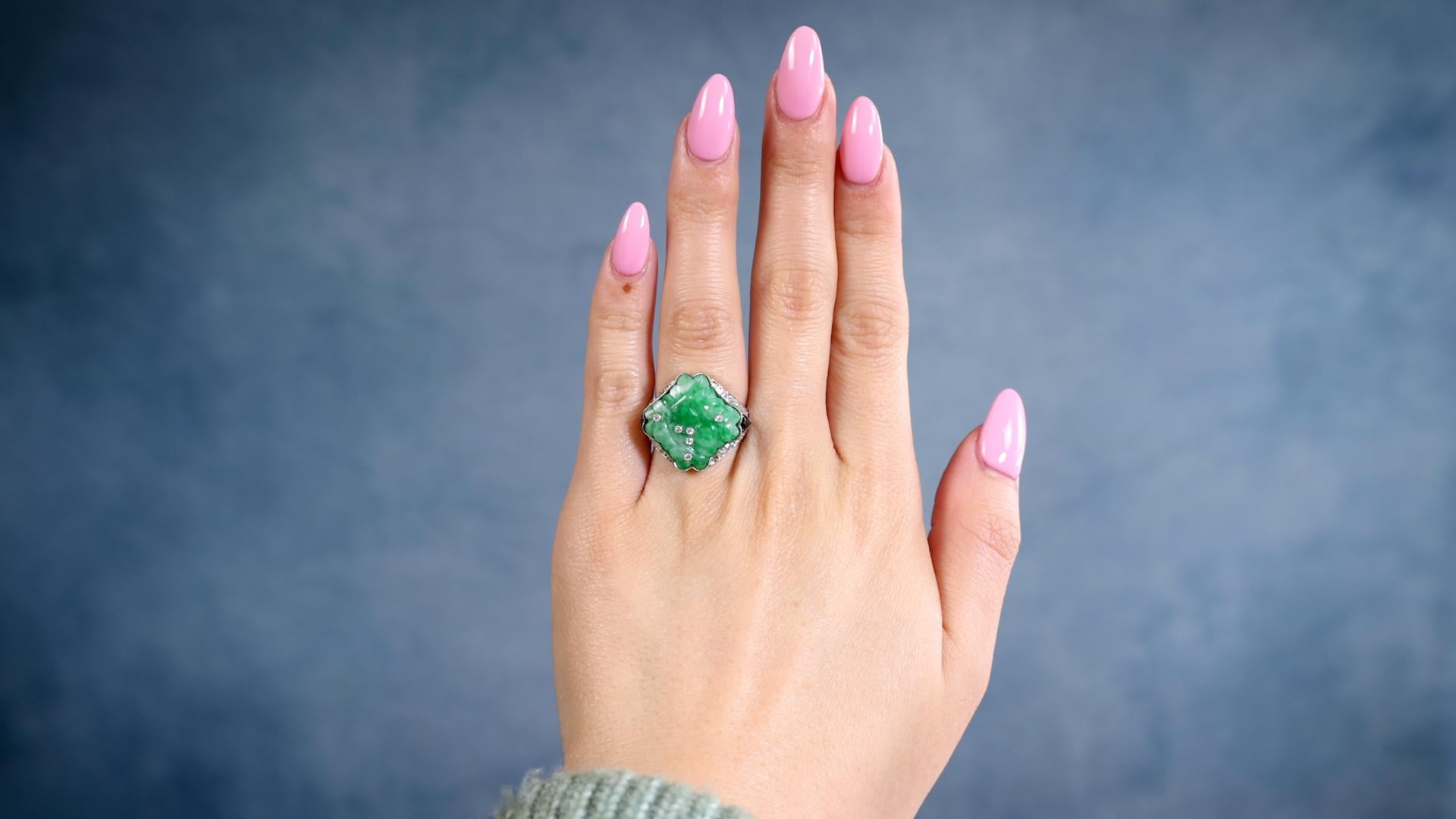 Ein von Art Deco inspirierter Ring aus Jade, Diamant und Onyx aus Platin. Mit einem geschnitzten Stück Jade. Akzentuiert durch sechs Diamanten im alten europäischen Schliff und 30 Diamanten im Senaille-Schliff mit einem Gesamtgewicht von ca. 0,35