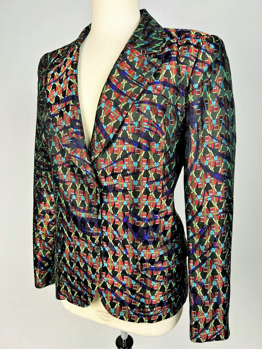Circa 2000
France
Beautiful jacket in shaped lamé from Christian Lacroix's Bazar collection, dating from 2000. Shouldered, slim-fitting jacket with baroque accents, fold-down collar, two flap pockets and front fastening with three wood-effect