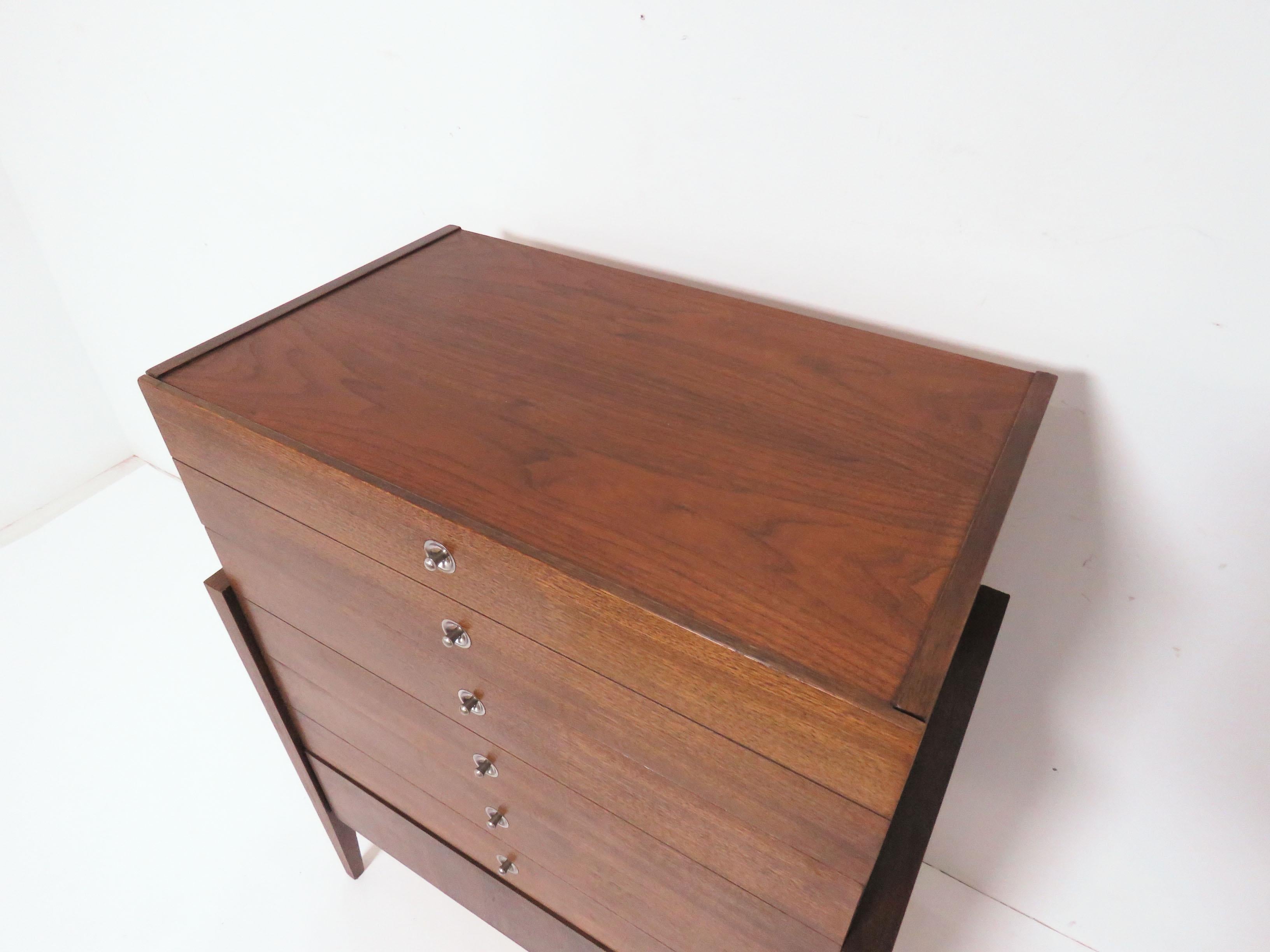 An Art Deco inspired walnut highboy four-drawer chest of American origin, circa 1950s.