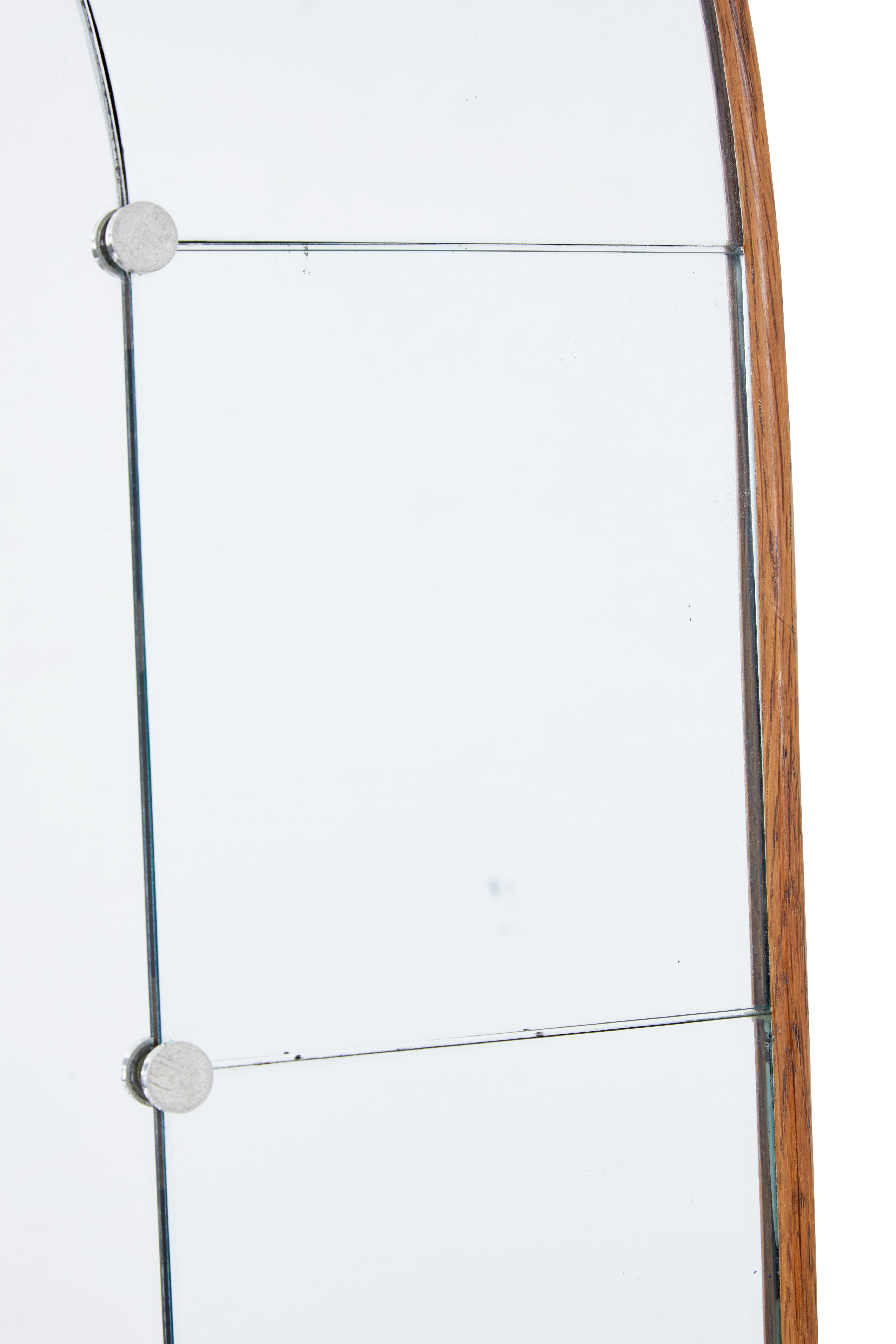 Fine quality arch shaped mirror, circa 1940.

Made with an oak frame, central panel which echoes the outside frame surrounded by panels held in place by screw in steel studs.

Minor plate loss to mirror.