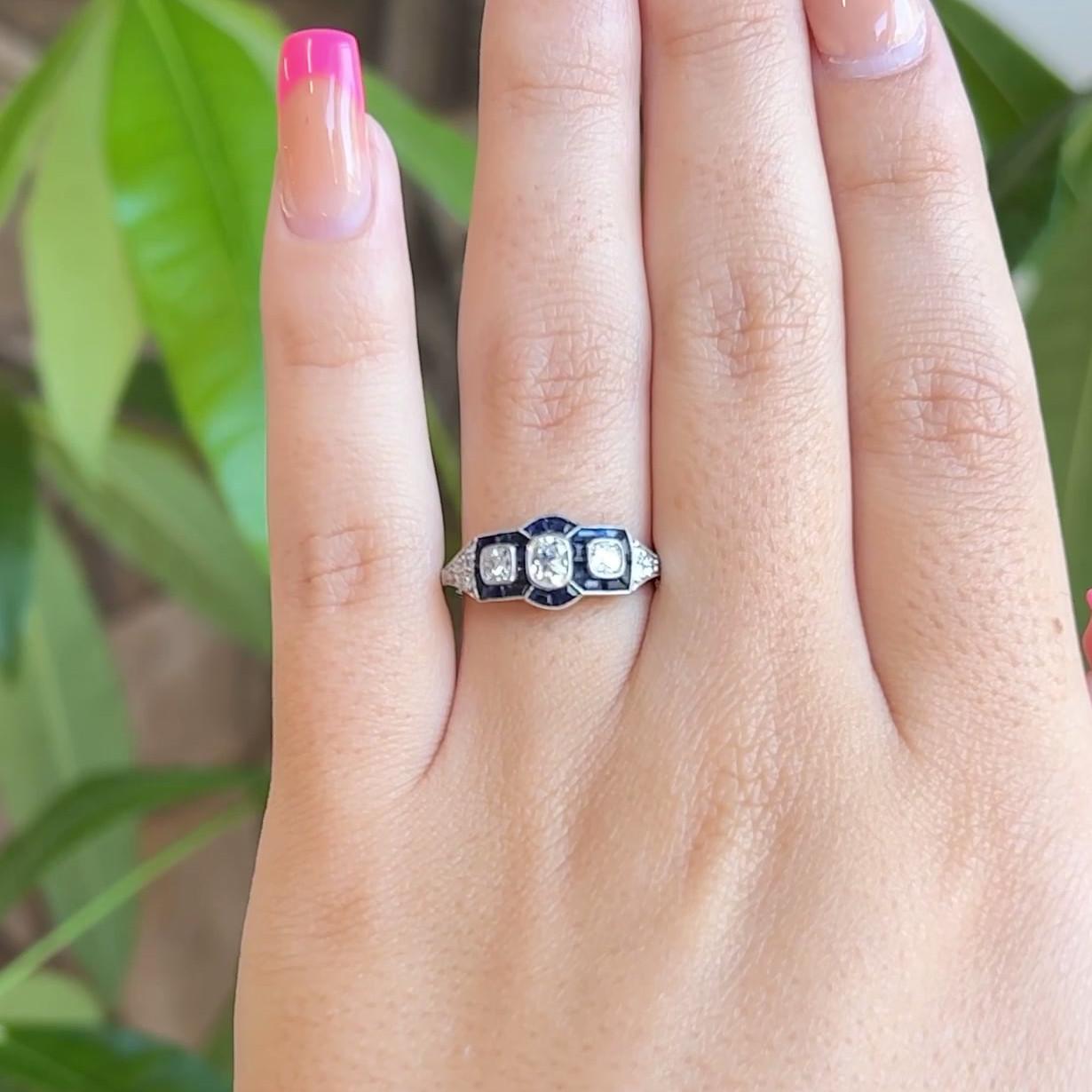 One Art Deco Inspired Old Cut Diamond Sapphire Platinum Three Stone Ring. Featuring one antique cushion cut diamond of approximately 0.30 carat, graded H color, VS clarity. Accented by two old mine cut diamonds with a total weight of approximately