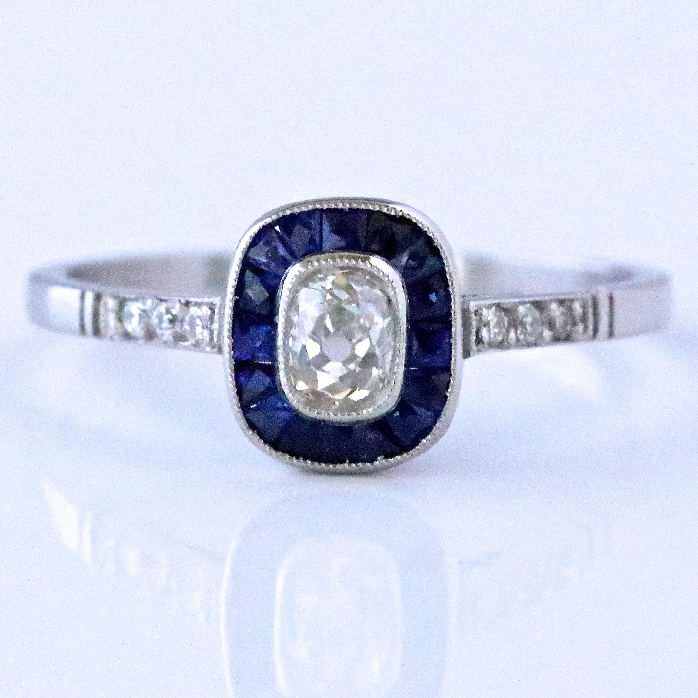 The Art Deco style never gets old! The dancing, the cocktails, the lifestyle, all the things the Roaring 20's are known for. Feel yourself like a 1920's fashionista wearing this gorgeous Art Deco Inspired Diamond Sapphire Platinum Ring. The center