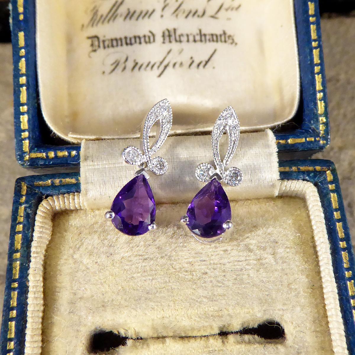 Dieses schöne Paar Ohrringe wurde in feiner Handarbeit gefertigt und erinnert an ein Stück aus der Art déco-Zeit. Das zierliche, mit Diamanten besetzte Looping-Design mit Millegrian-Fassung verleiht dem Schmuckstück aus 18-karätigem Weißgold die