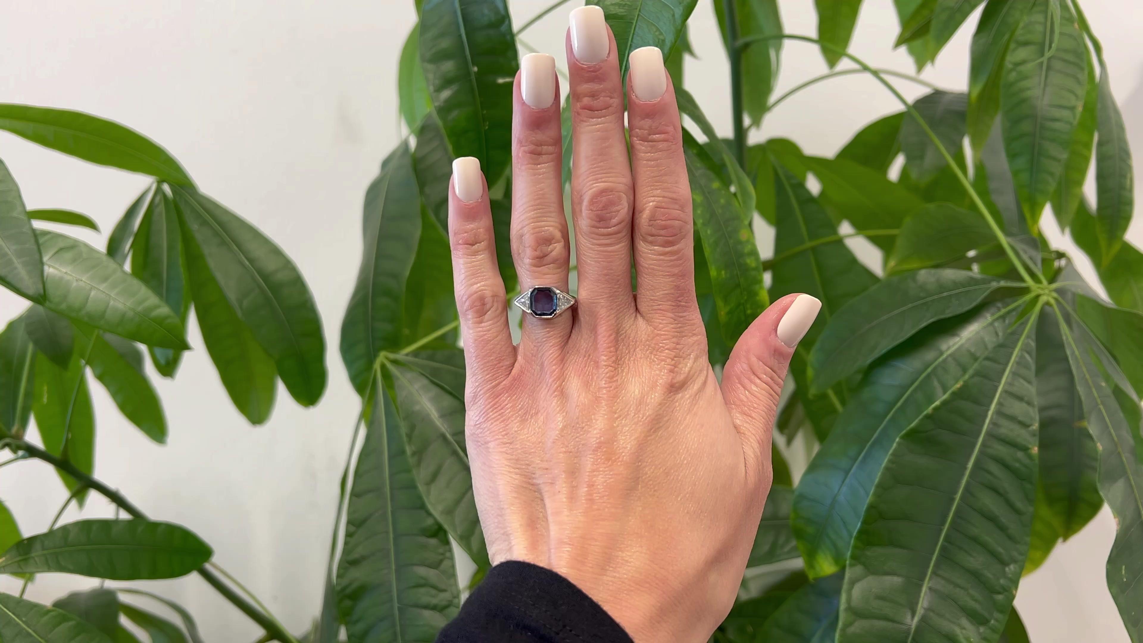 One Art Deco Inspired Portrait Cut Sapphire Diamond Platinum Ring. Featuring one portrait cut violetish blue sapphire weighing approximately 1.10 carat. Accented by two trillion cut diamonds weighing a total of approximately 0.60 carats graded I