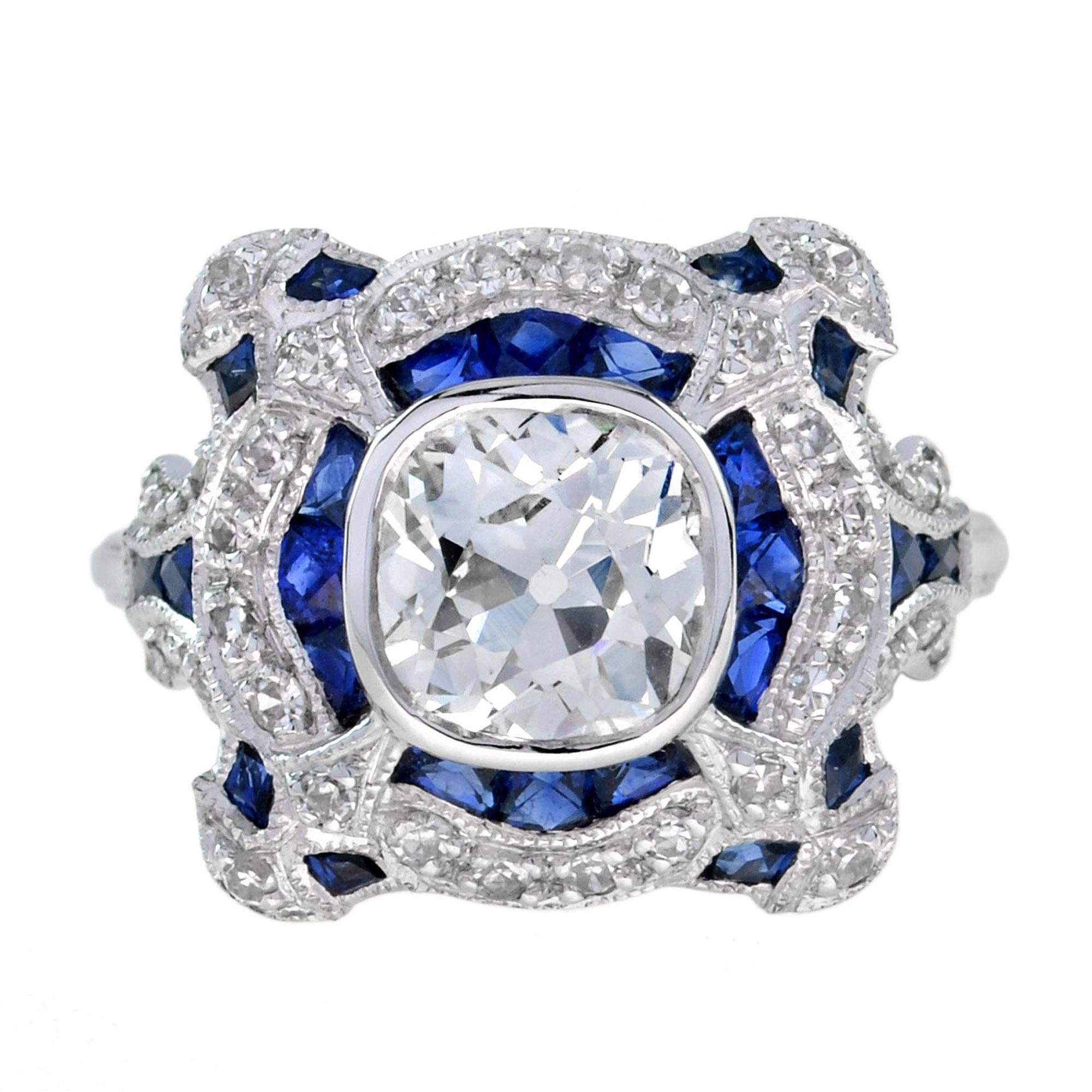 Cette magnifique bague en diamant de style Art-Déco est dotée d'un anneau de forme ronde incrusté de saphirs bleus et de diamants naturels. La pièce maîtresse est un diamant taillé dans une ancienne mine, de couleur J et de pureté VS2. Les saphirs