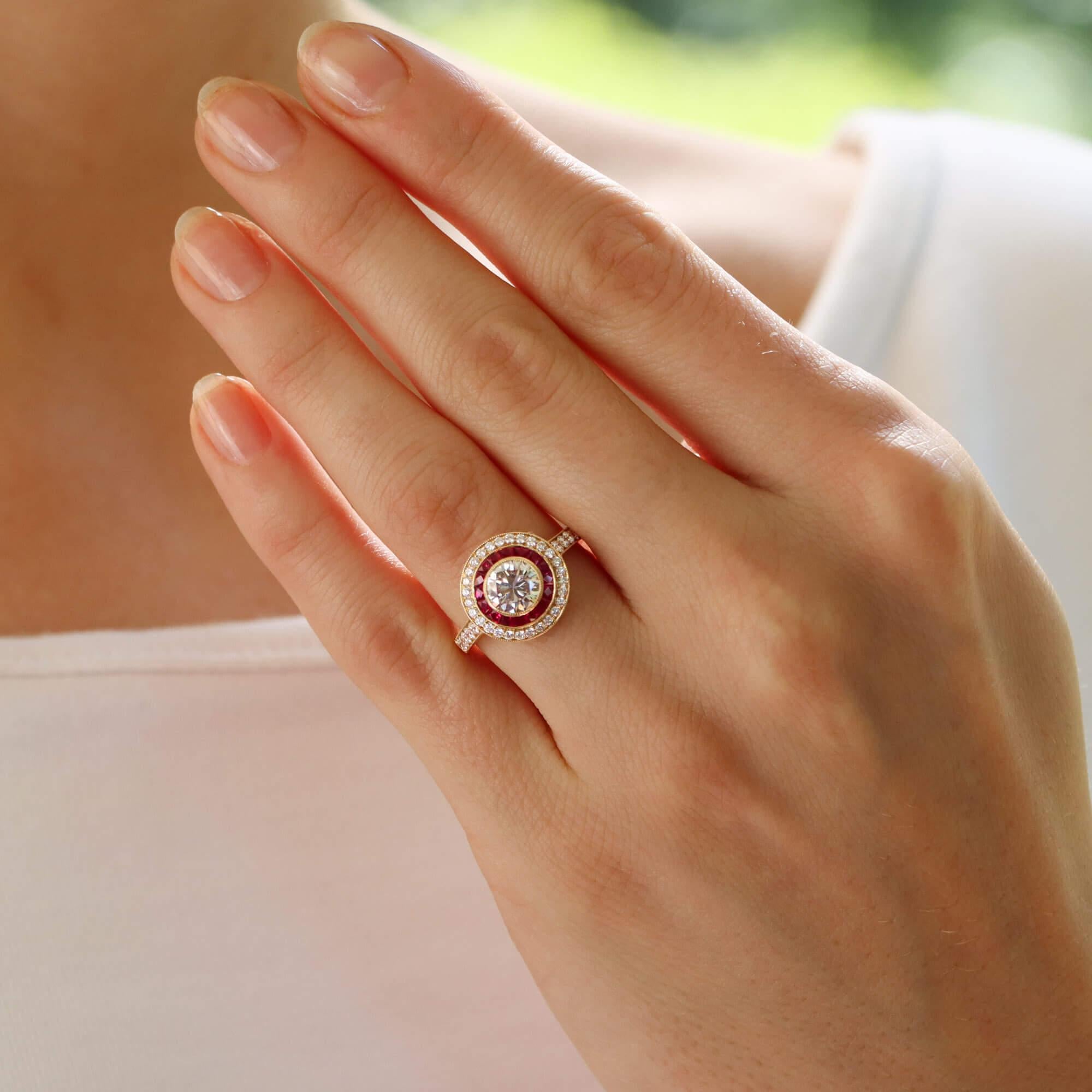 Un bellissimo anello di fidanzamento a doppio bersaglio con rubino e diamante in stile Art Déco, incastonato in oro giallo 18 carati.

L'anello è caratterizzato da uno scintillante diamante rotondo taglio brillante, incastonato in modo sicuro al