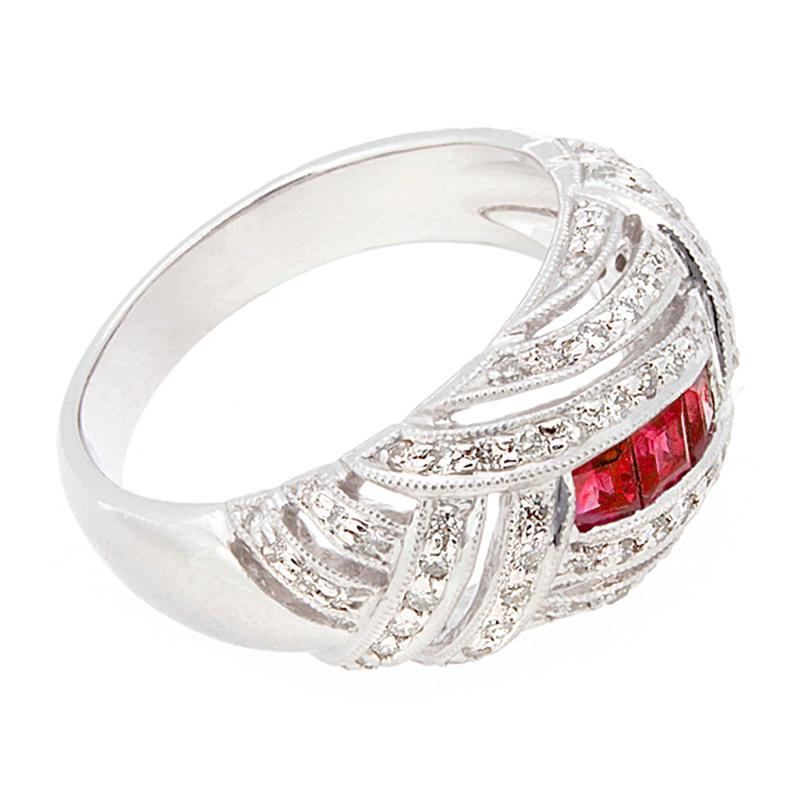 An Art Deco inspired ring featuring three princess cut rubies weighing 0.42 carats, with 0.60 carats of diamonds.  The ring is set in platinum, where the platinum setting crosses over each other giving the piece its fantastic deco look. 

Currently