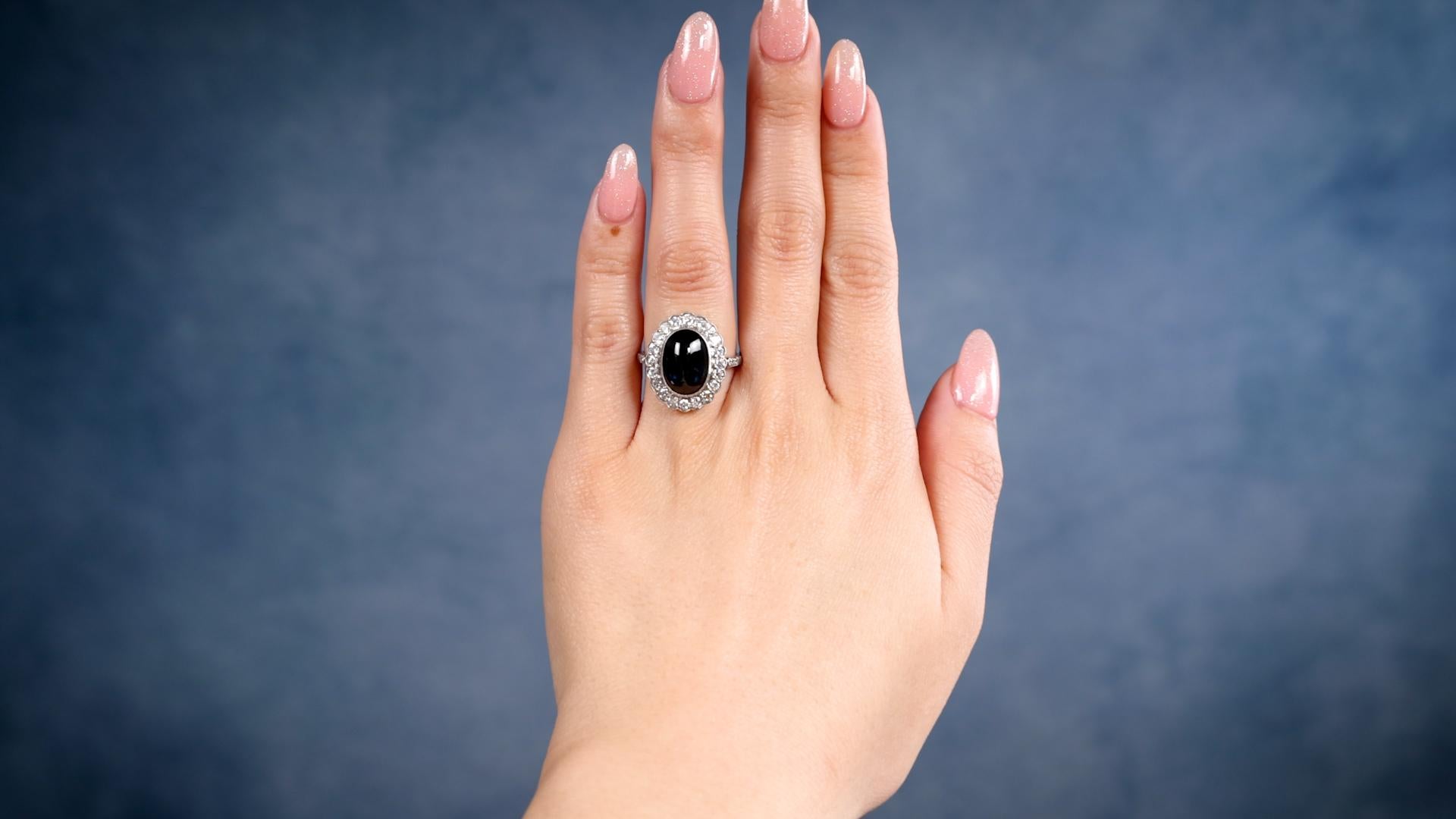 Ein Art Deco inspiriert Saphir Diamant Platin Halo Cluster Ring. Mit einem Saphir im Cabochon-Schliff von 3,70 Karat. Akzentuiert durch 26 runde Diamanten im Brillantschliff und im alten europäischen Schliff mit einem Gesamtgewicht von ca. 1,30