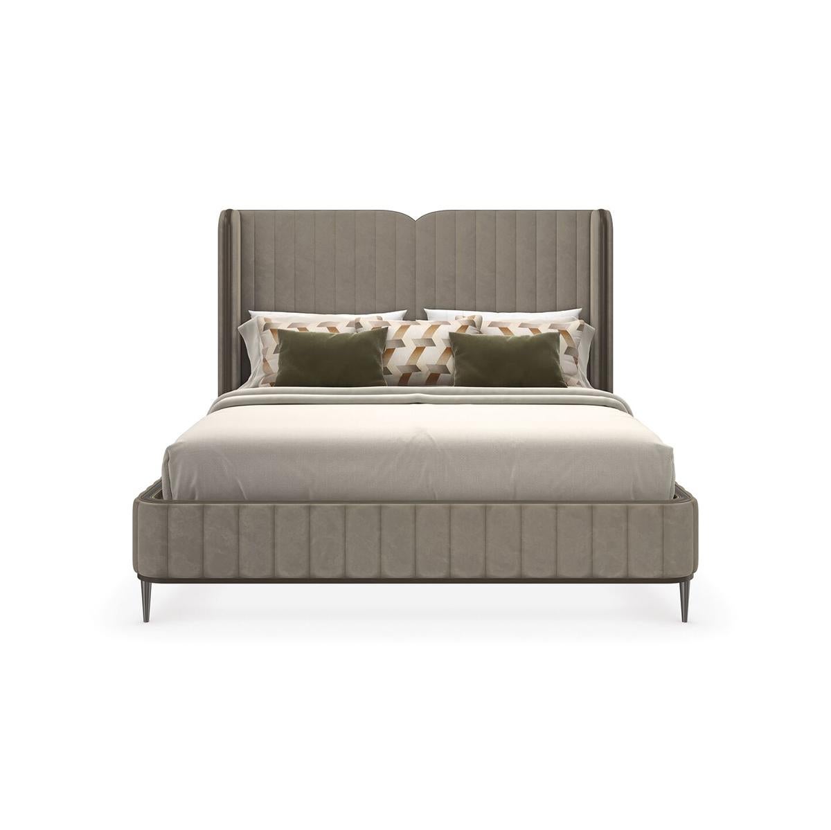 This is a contemporary velvet upholstered bed, featuring a high headboard with distinct vertical channel tufting that gives it a plush, sophisticated appearance. The vertical channel tufting goes uninterrupted, except for a slight dip at the center