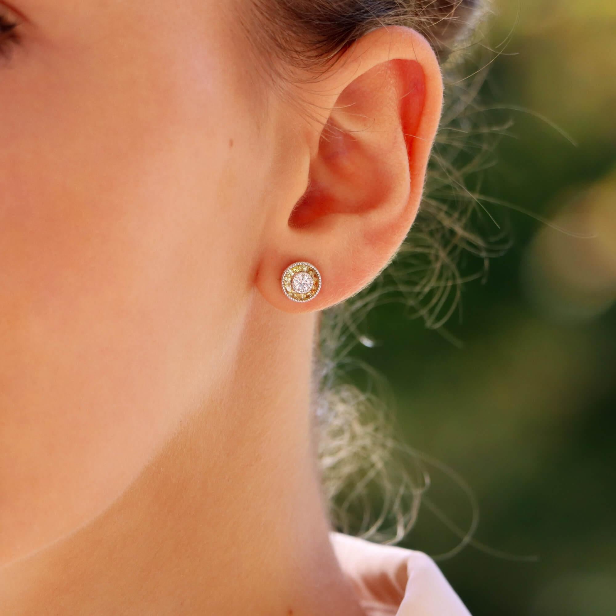 A beautiful pair of Art Deco style diamond and yellow sapphire target earrings set in 18k white gold.

Each earring is predominantly set with a sparkly round brilliant cut diamond which is rub over set to centre. Each diamond is then elegantly