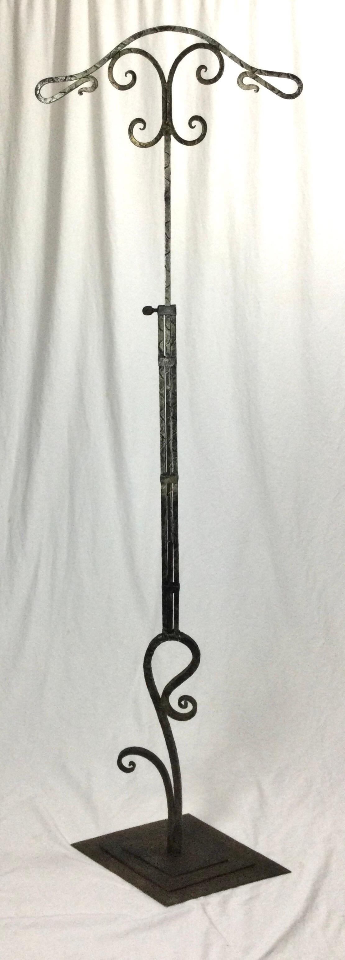 Early 20th century Art Deco iron adjustable clothing display valet stand. I was told that this stand came from a NYC Mens Clothing store. It is photographed at its lowest position of 34 1/2