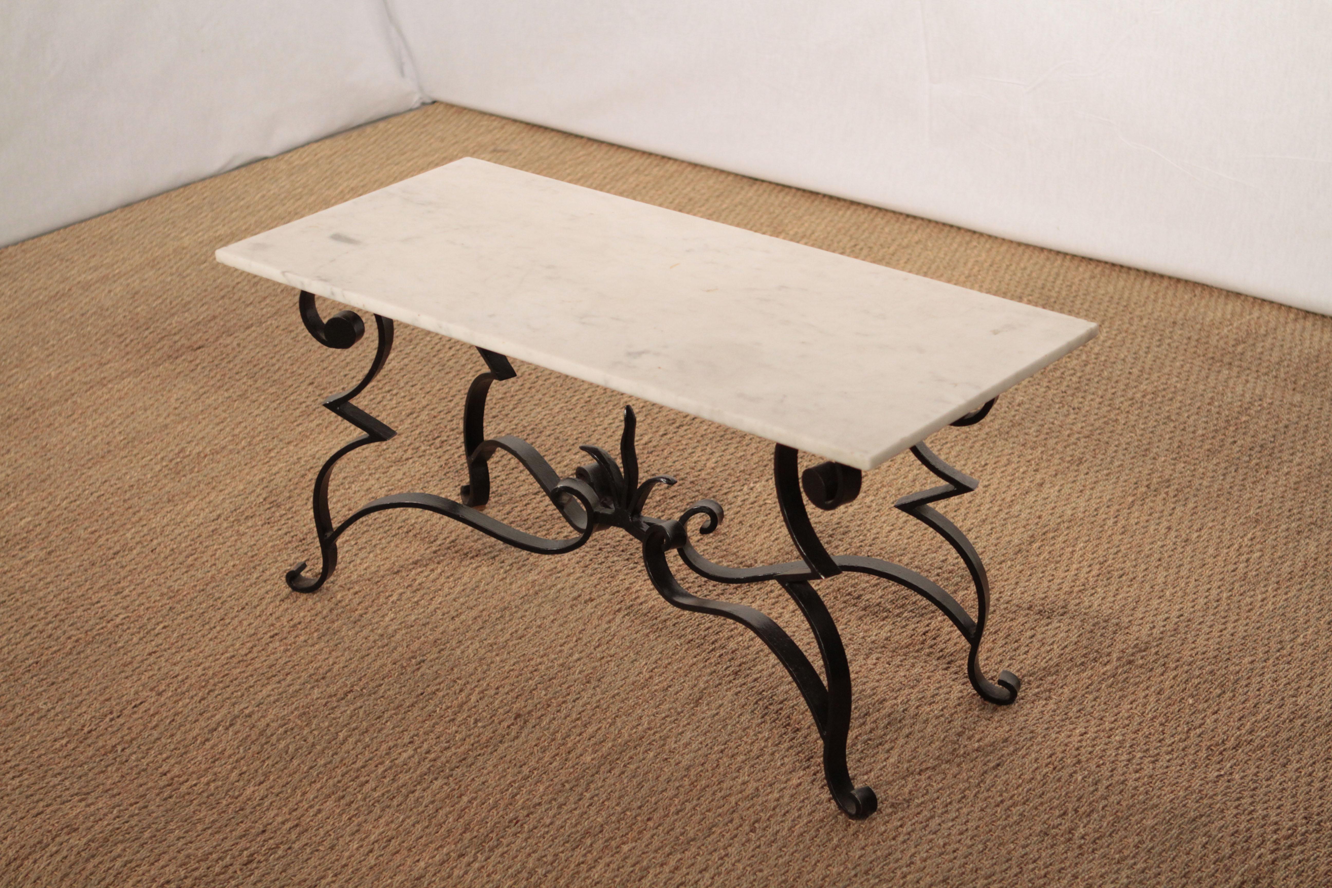 The ironwork in this coffee table from the 1950s is as uncommon as it is gorgeous. Made by a French art deco ironworker, the table features artfully and skilfully black wrought iron feet, reminiscent of Raymond Subes work, which now display stunning
