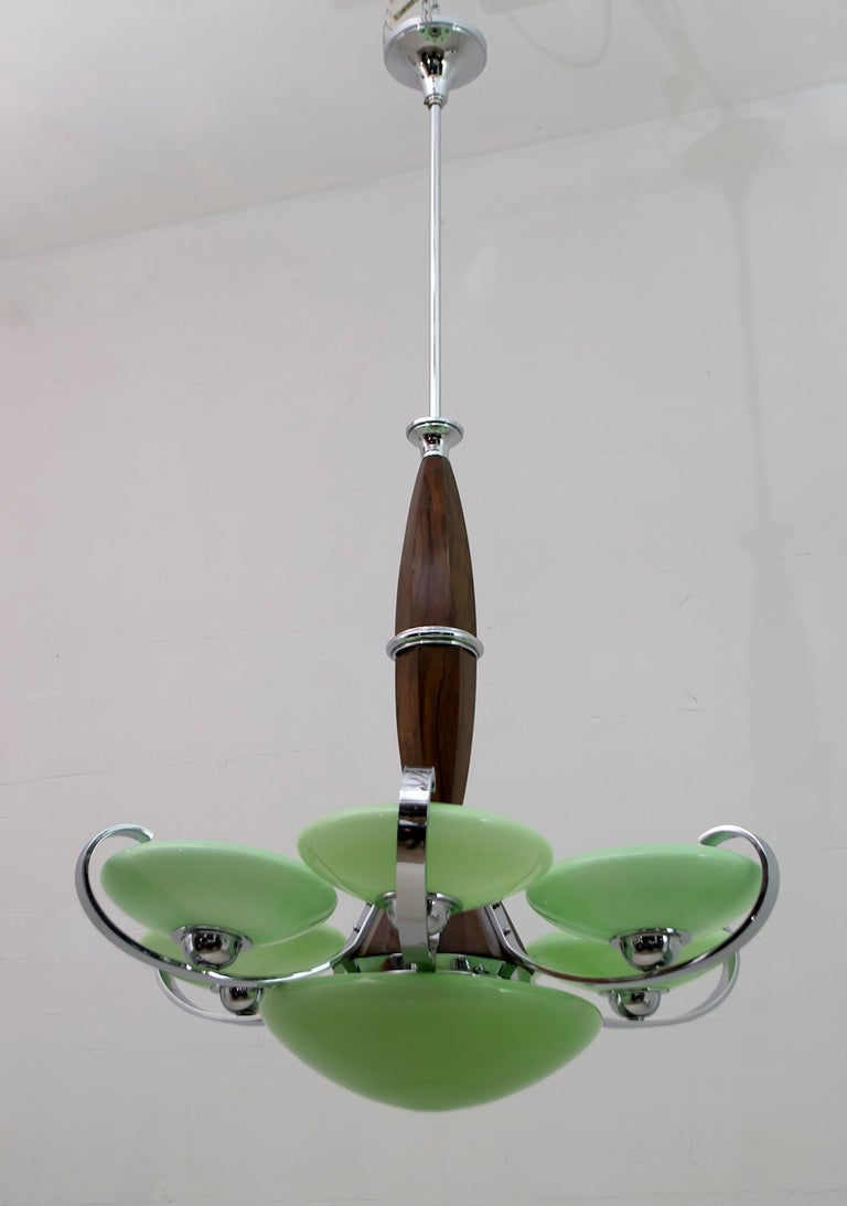 Art Deco chandelier made in Italy in the 1930s. The structure is in chromed metal and wood, the bowls in Murano glass 