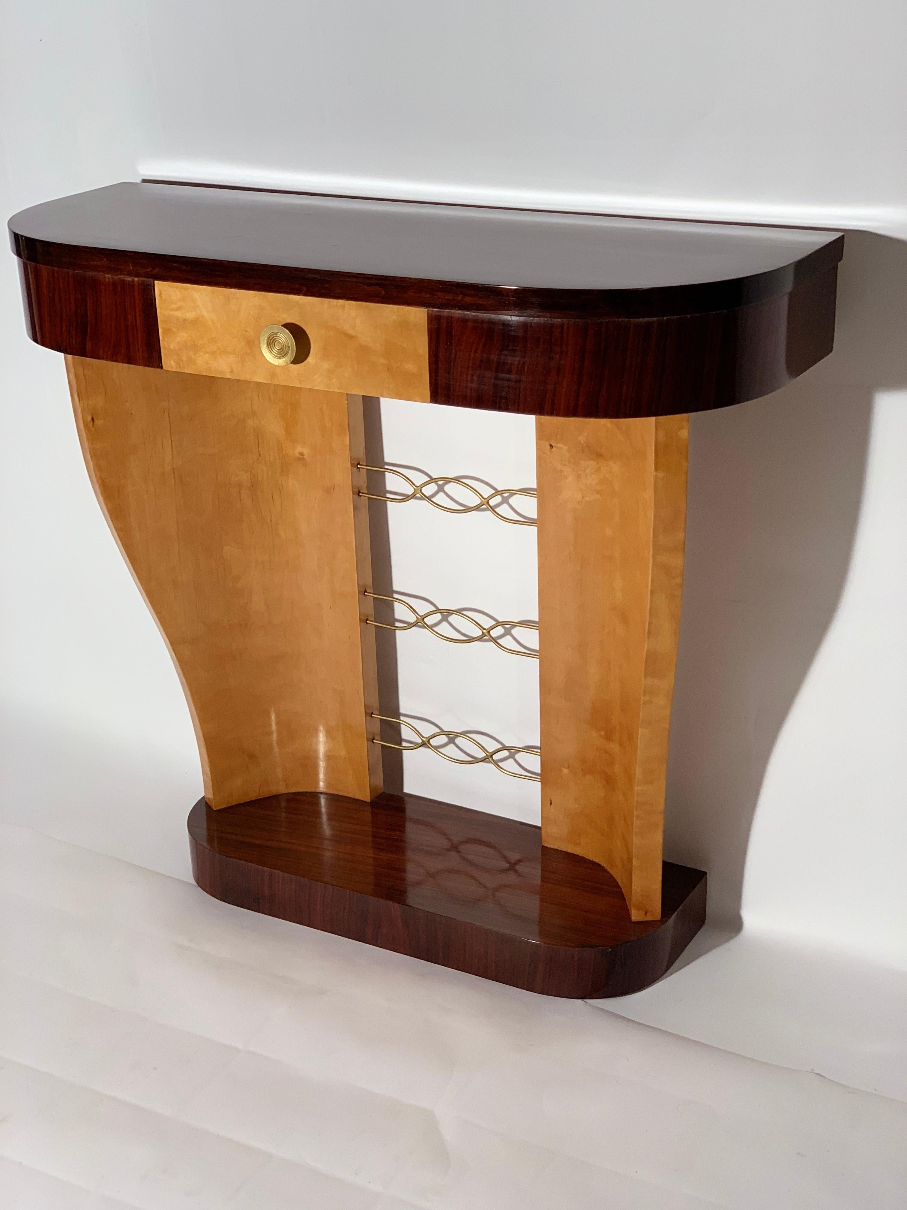 Italian Art Deco Consolle, bird yes maples wood and exotic precious wood that create a contrast between dark and light colors.
Base curved at the corners with overhanging two curved maple supports joined by a brass decoration, supporting the curved