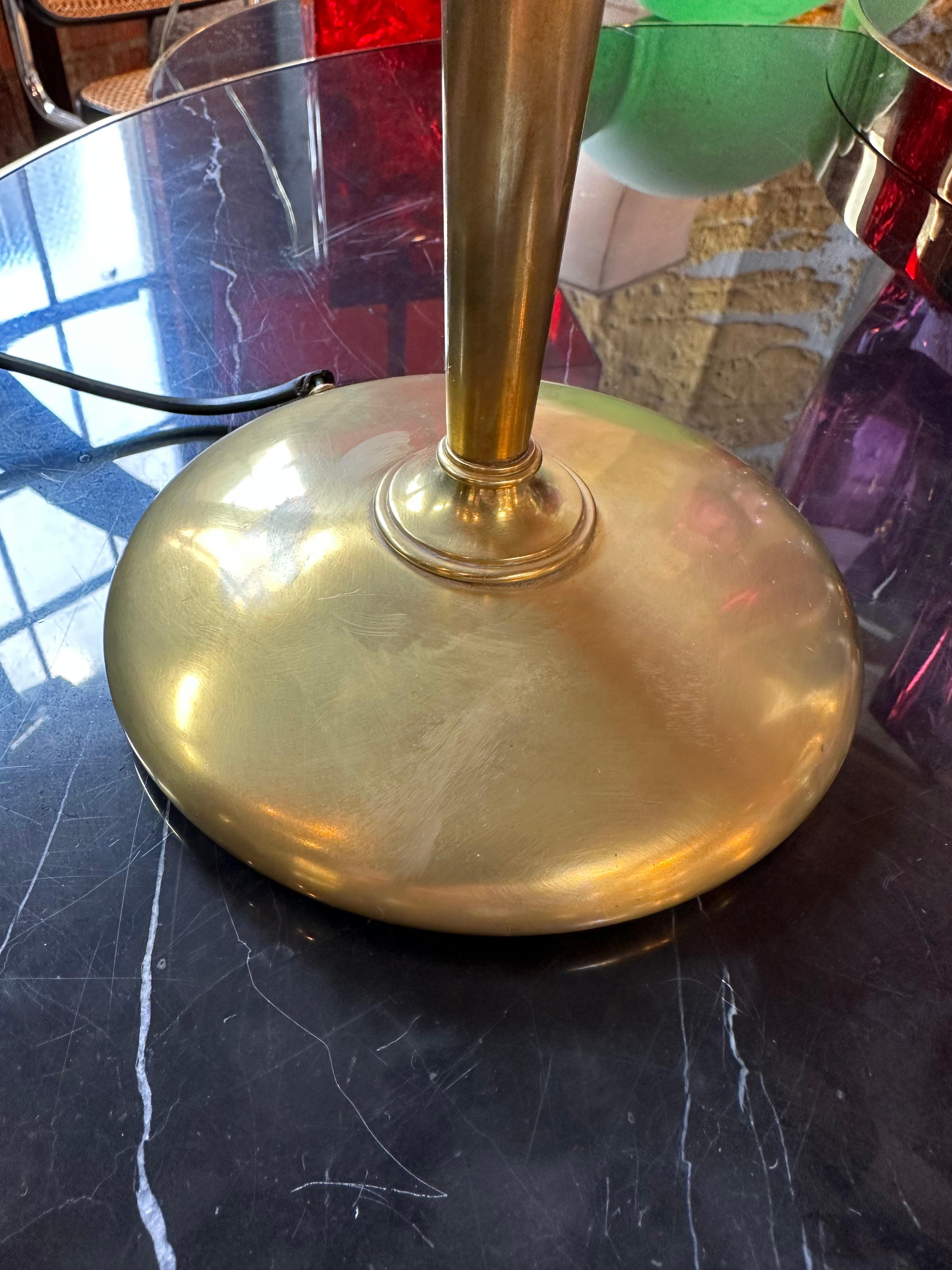 Certainly! An Art Deco Italian table lamp fully made of brass from the 1960s is likely to feature a sleek and polished design with clean, geometric lines. The brass material lends the lamp a sense of luxury and opulence, and the lamp may be