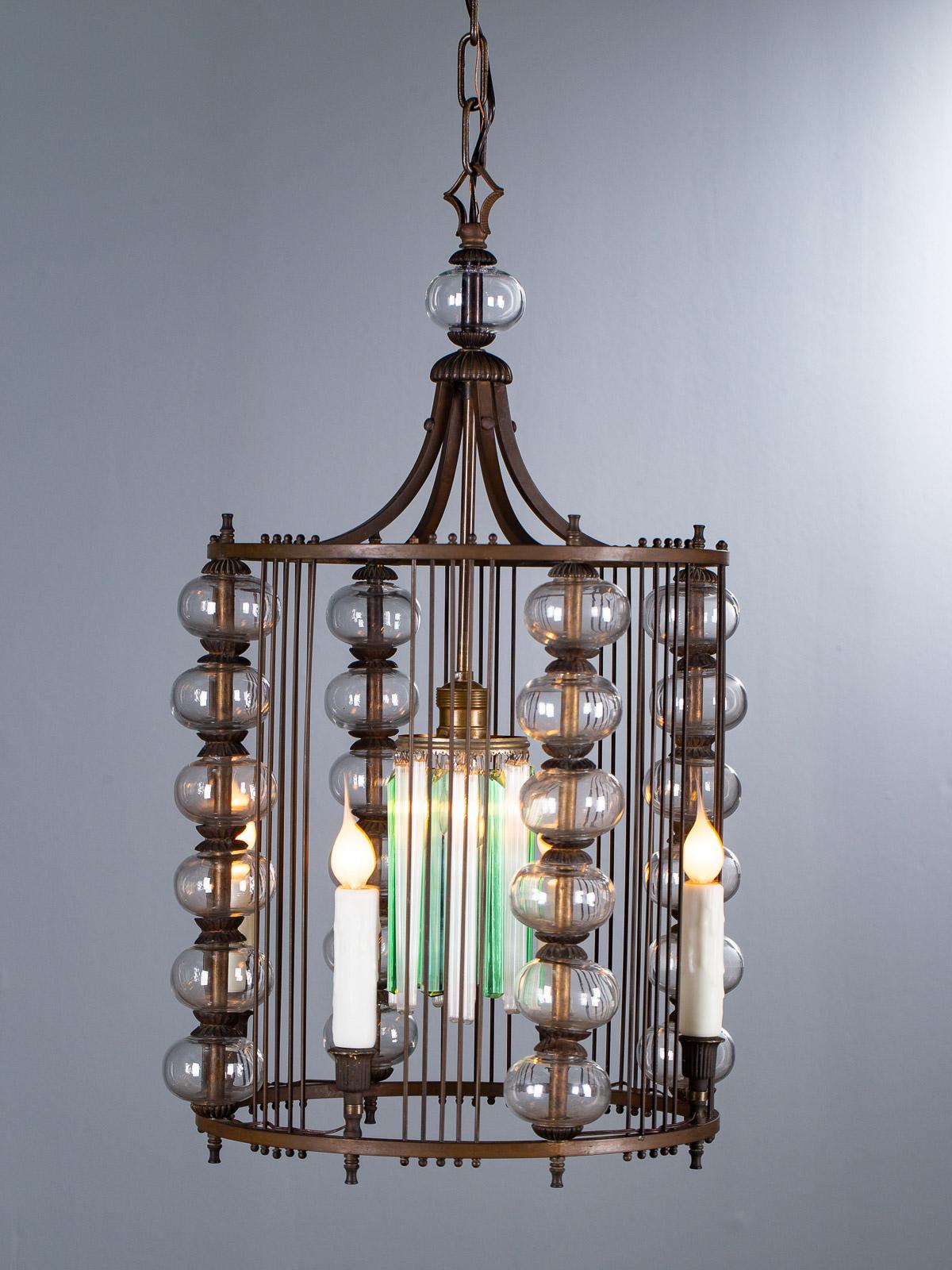 A gorgeous Italian Art Deco iron and glass lantern light fixture, circa 1940. This lantern is just wow. The cylinder shape has four sections each defined by the series of glass spheres that separate the iron rods that connect the upper and lower