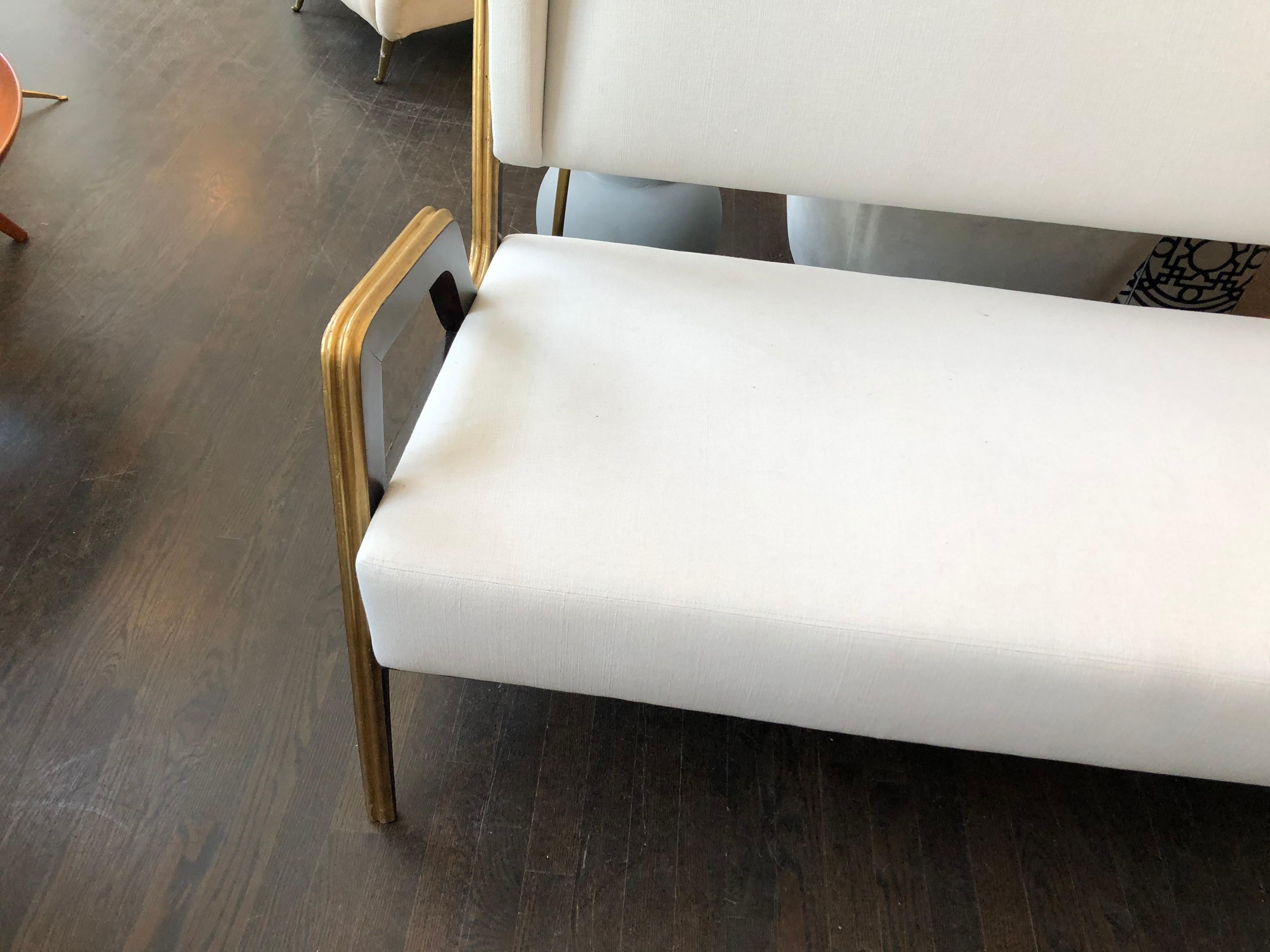 Dieses italienische Art-Déco-Sofa weist markante neoklassische Elemente auf, wie die kannelierten Schnitzereien an den Arm- und Beinteilen und die Verwendung von klassischem schwarzem Lack mit goldenen Highlights auf den Holzoberflächen. Mit seinen