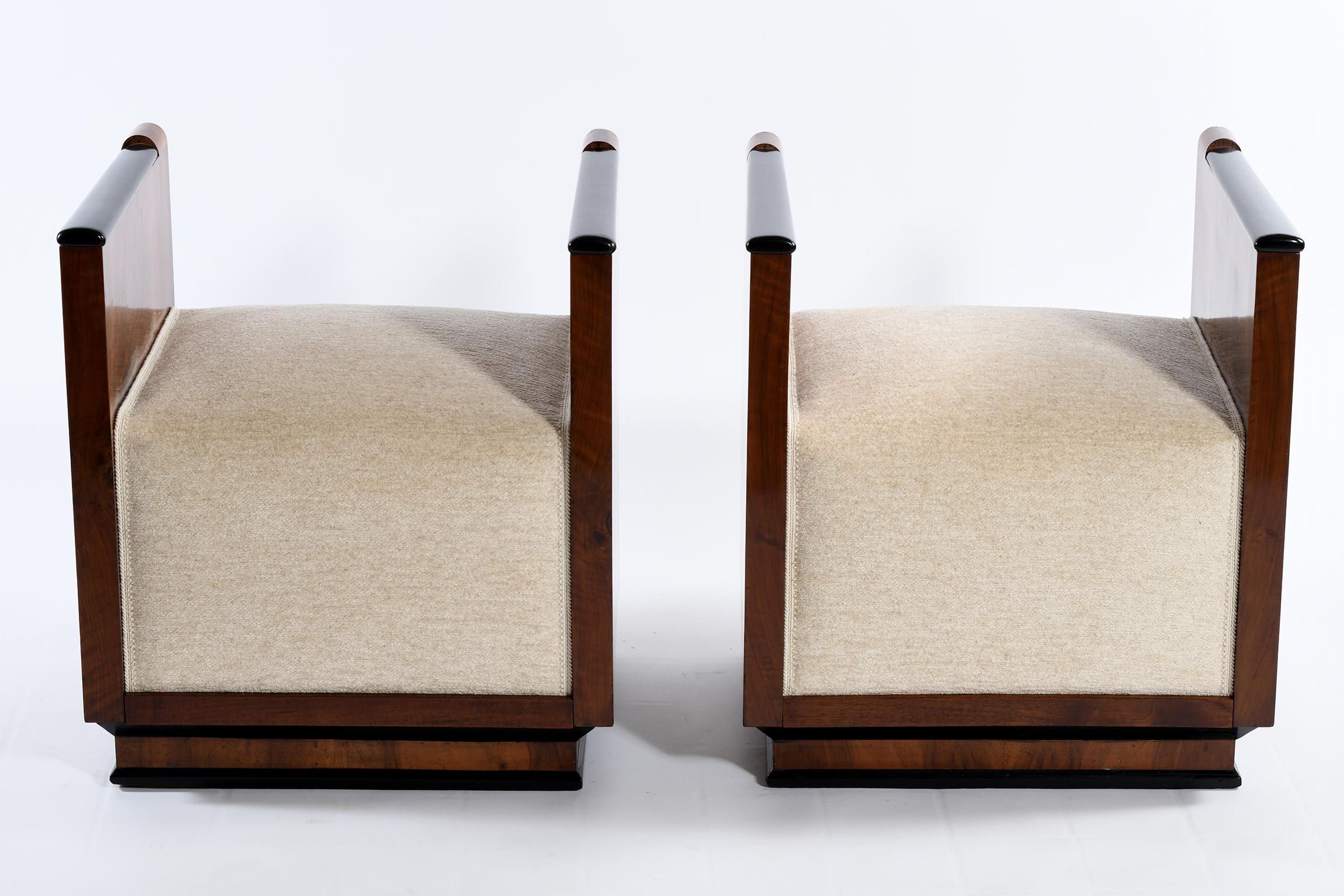 Pair of Italian Art Deco stools sides with splendid walnut in warm color, the black lacquer details border and enhance the elegance of the geometric and rigorous design, the armrests widen on one side and tighten towards the other, the base also