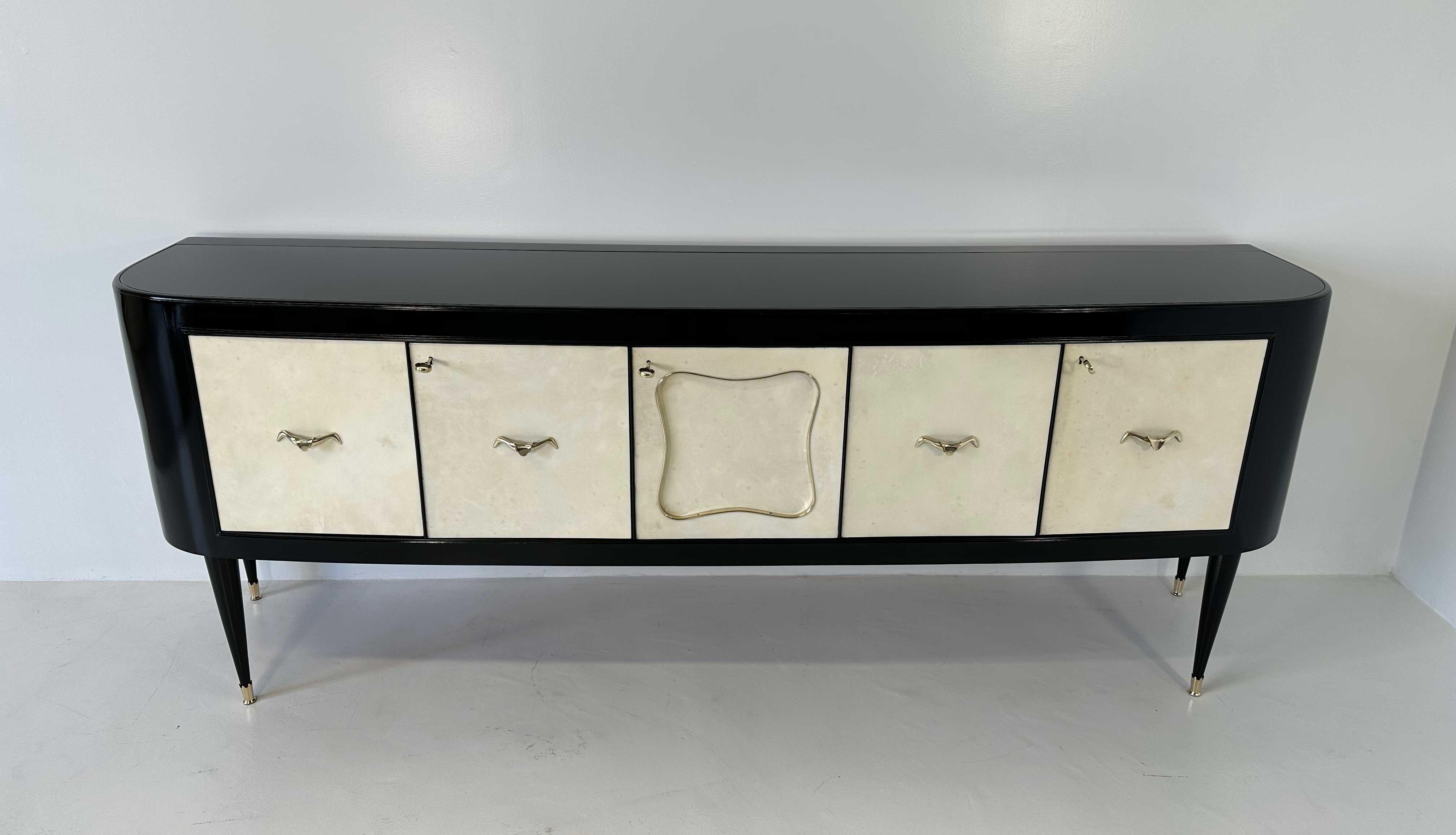 Dieses elegante Sideboard wurde in den 1950er Jahren in Italien hergestellt. 
Die fünf Türen sind aus Pergament, umrahmt von der Struktur und den schwarz lackierten Beinen. 
Die Innenräume sind aus Holz, während das Innere der zentralen Tür eine