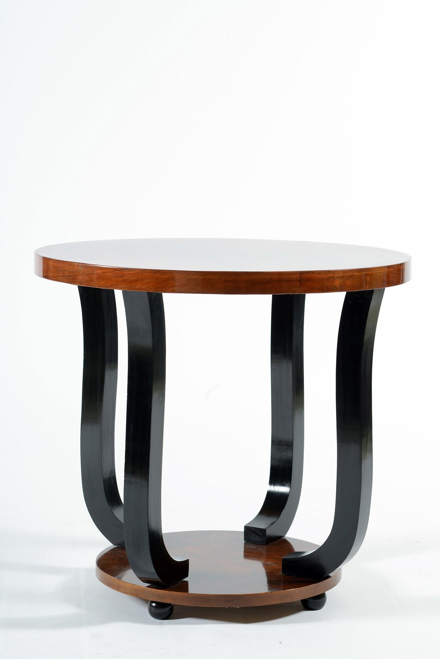 Round double shelves Art Deco side table, four curved black lacquered legs and walnut burr top.
Italia, 1930.