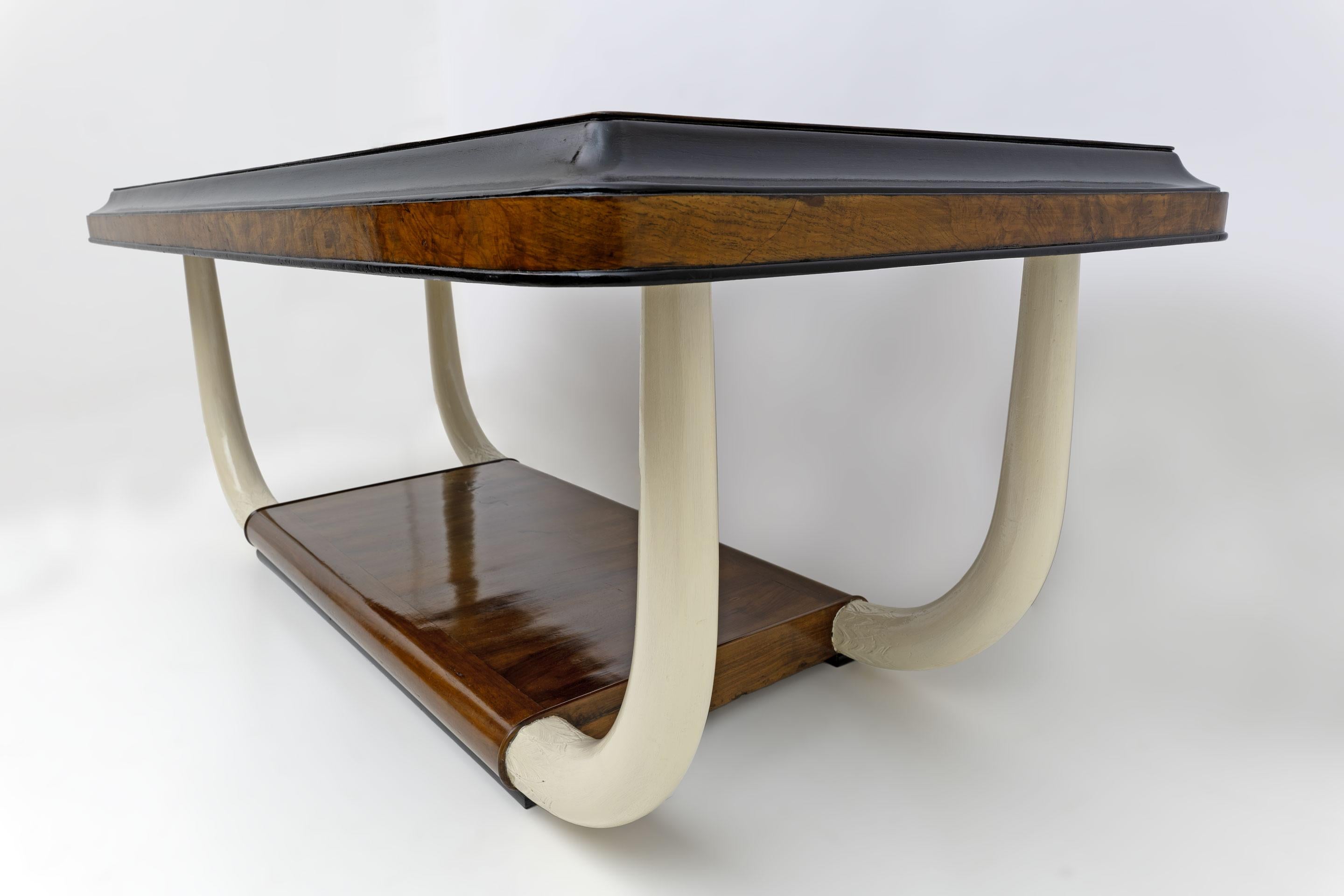 Art Deco style table or desk, produced in the colonial period, as confirmed by the legs in the shape of elephant tusks in ivory lacquered wood. Top in black glass, walnut root and ebonized wood. Completely restored and shellac polished.