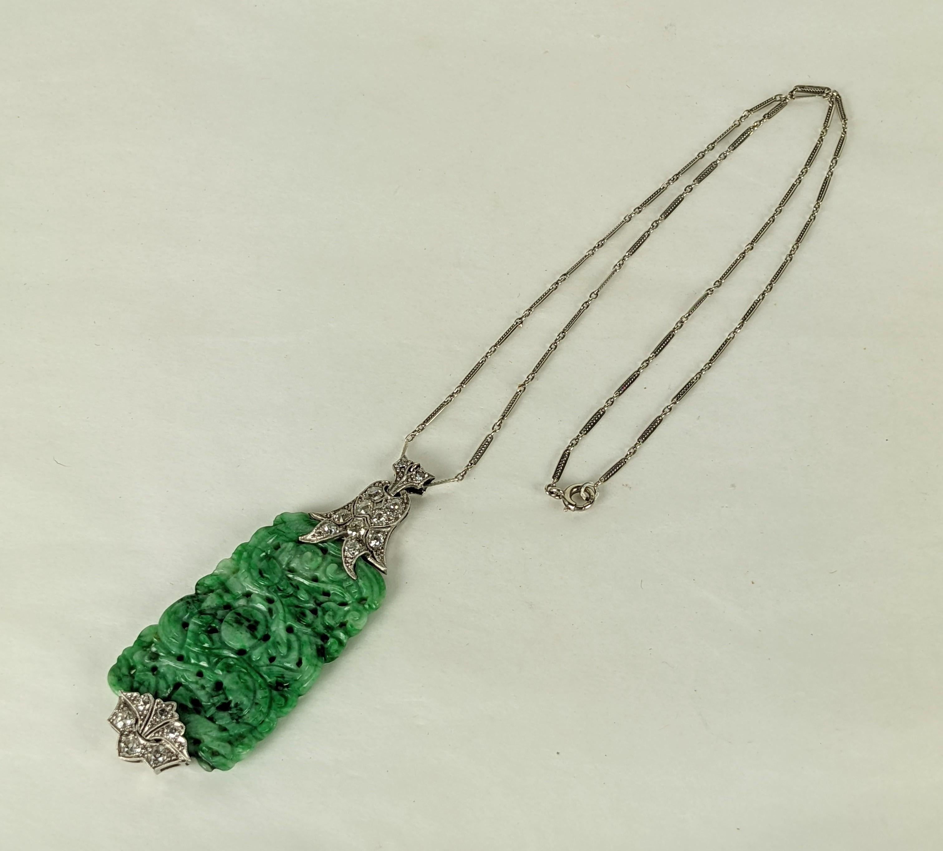 Art Deco Jade Diamond Pendant set in 18k platinum. Antique carved jade panel is held by diamond deco floriform hilts. Bright European cut diamonds throughout. Ornate twisted bar link chain in 18K. 
1930's. Necklace 17