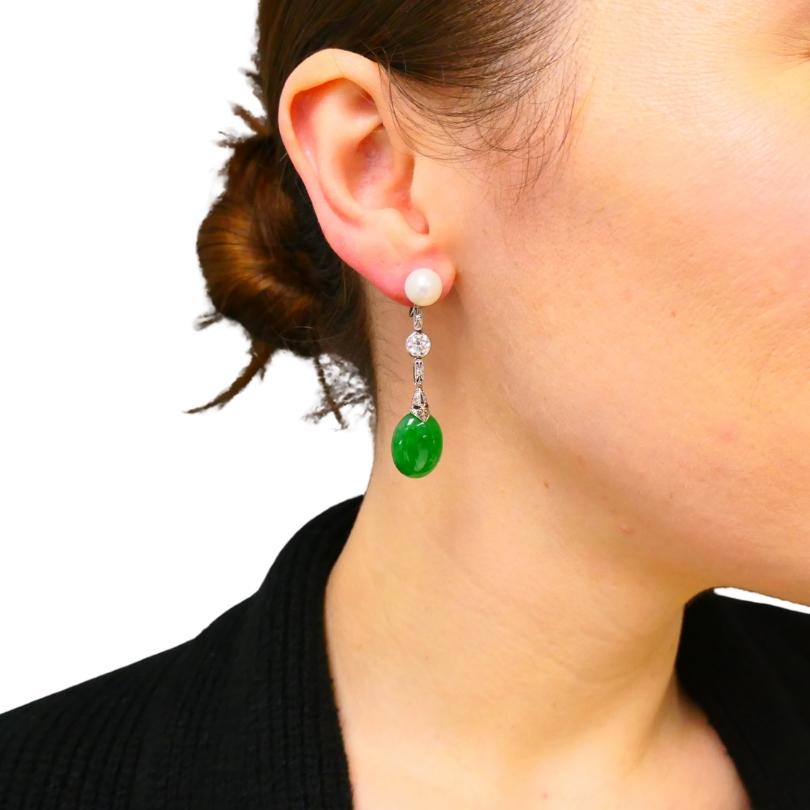 Ein Paar wunderschöne Art-Déco-Jade-Ohrringe aus Platin mit einer auffälligen Kombination aus Jade, Perlen, Alt-Europäischen Diamanten und Diamanten im Einzelschliff.
An der Spitze des Ohrrings sitzt eine knopfförmige Perle, die das Gesamtdesign