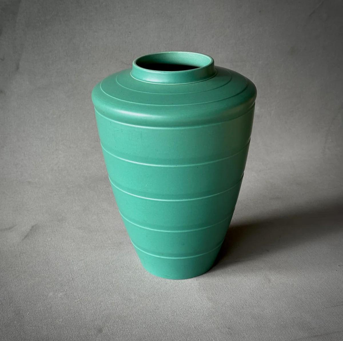 Ce vase Wedgwood d'un vert jade éclatant, conçu par l'artiste renommé de l'Art déco Keith Murray, est un bel exemple d'élégance rationalisée. Ses lignes épurées, doucement effilées et son motif géométrique sobre mettent en valeur la finition mate,