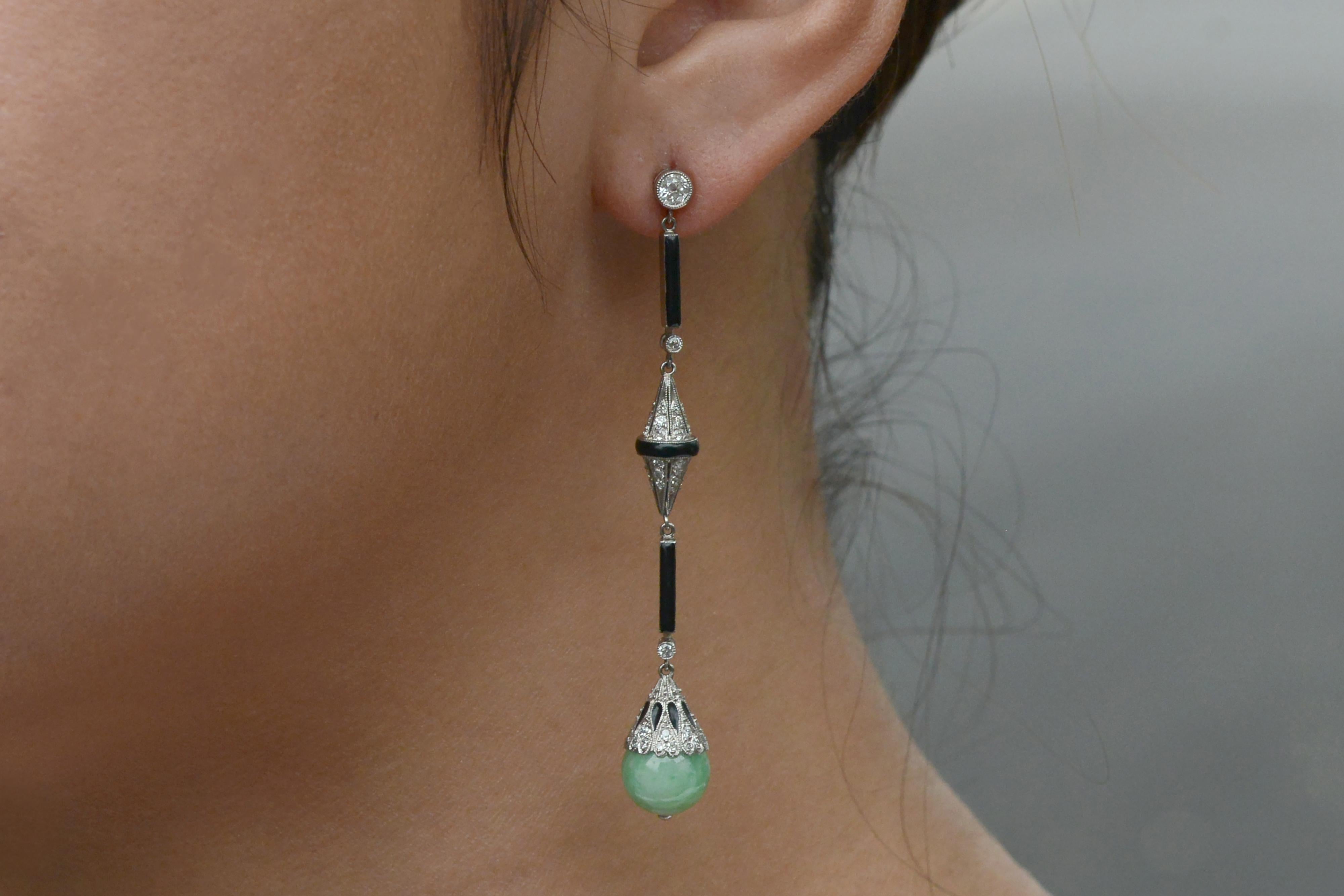 These daring and dazzling dangles are quite the pair! Reigning from the Art Deco era, these long drop earrings descend upon a dynamic combination of jade, black onyx and brilliant old European cut diamonds. Finishing off this ravishing combination