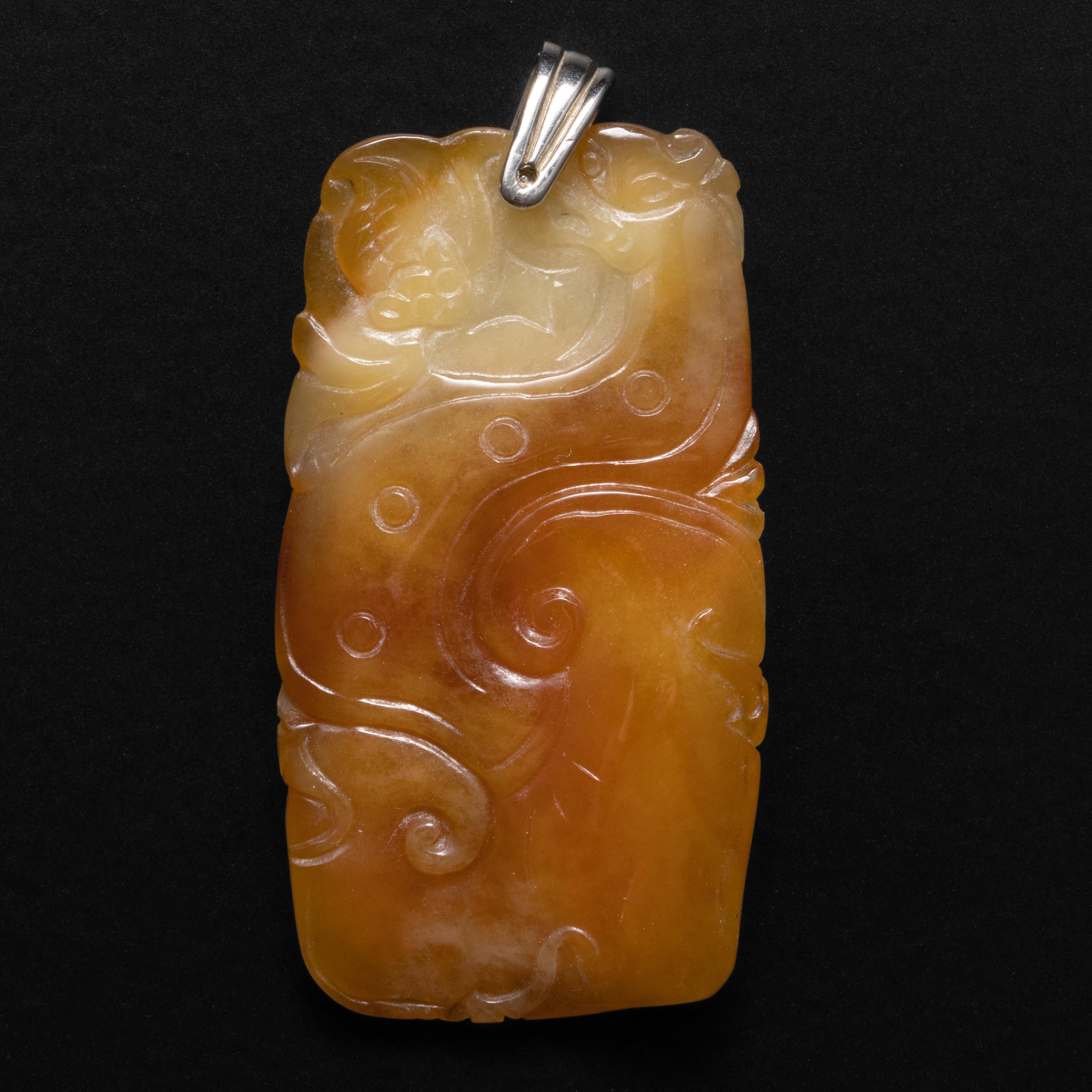 Dieser Art-Deco-Anhänger (um 1930) aus Jade hat die Farbe von hausgemachtem Karamell. Es ist die Farbe des Karamells, nachdem man den Zucker zu einem goldenen Sirup geschmolzen hat und die dicke, süße Sahne einrührt. Dieser prächtige,