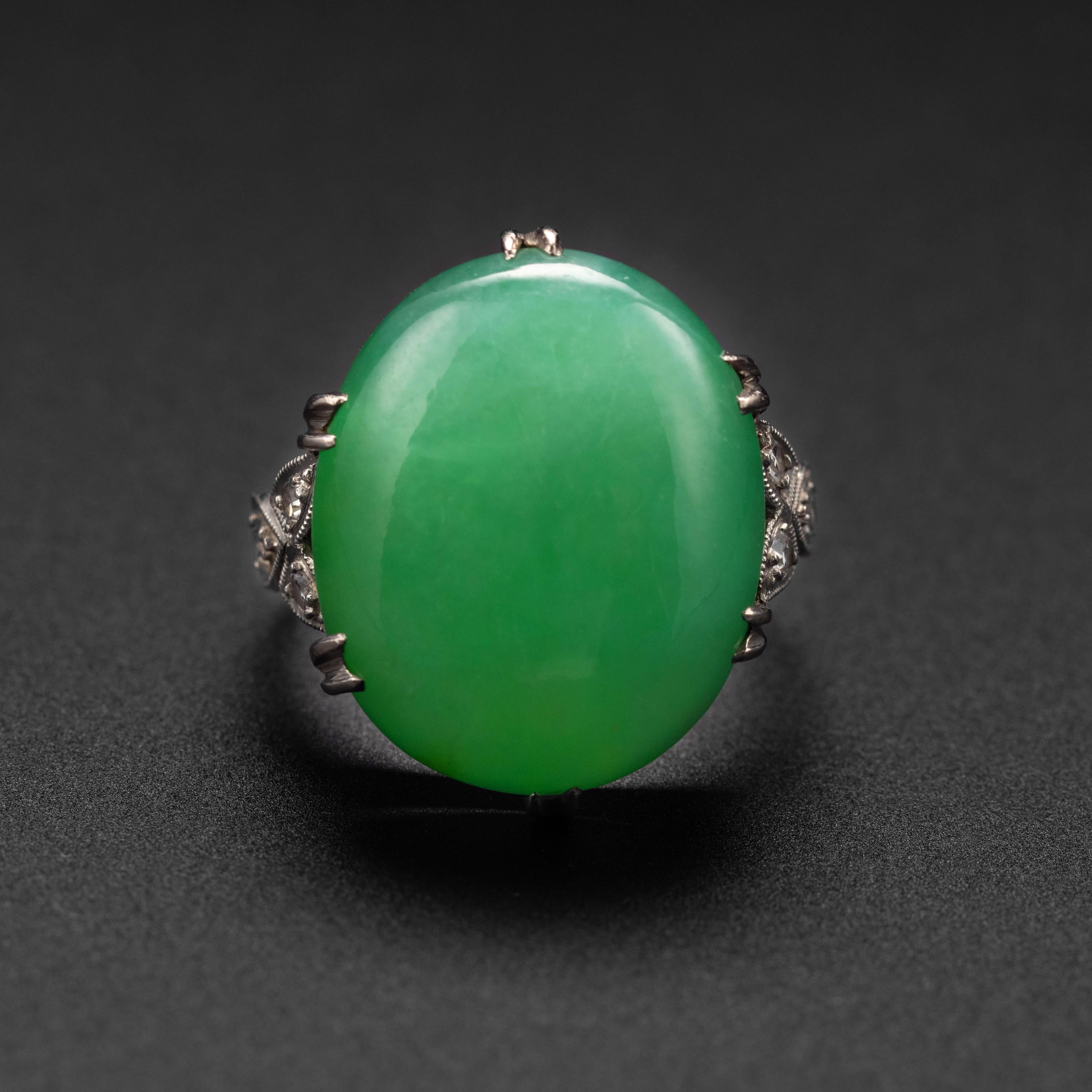 This impeccable Art Deco-era ( circa 1930s) platinum ring features a cabochon of natural and untreated light apple green jadeite jade that is plump and bursting with light. The jade is actually a double cabochon; an old-school lapidary technique